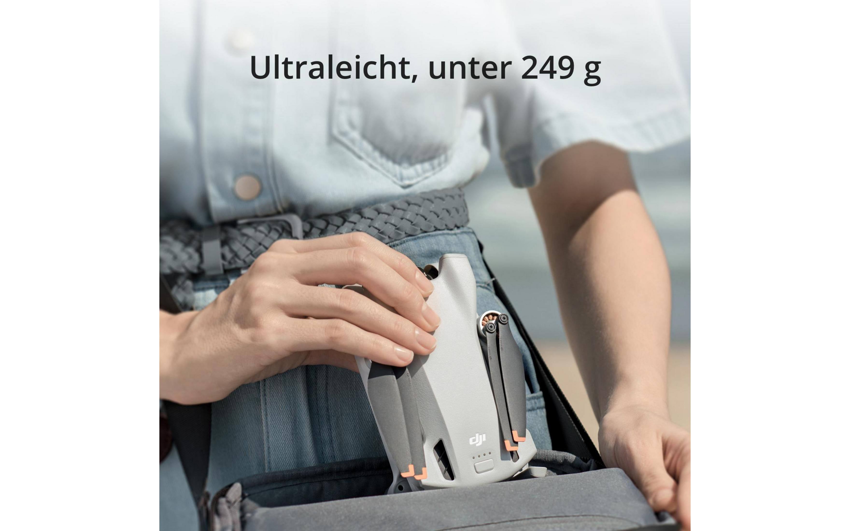 Osoba trzymająca małego drona w kieszeni.