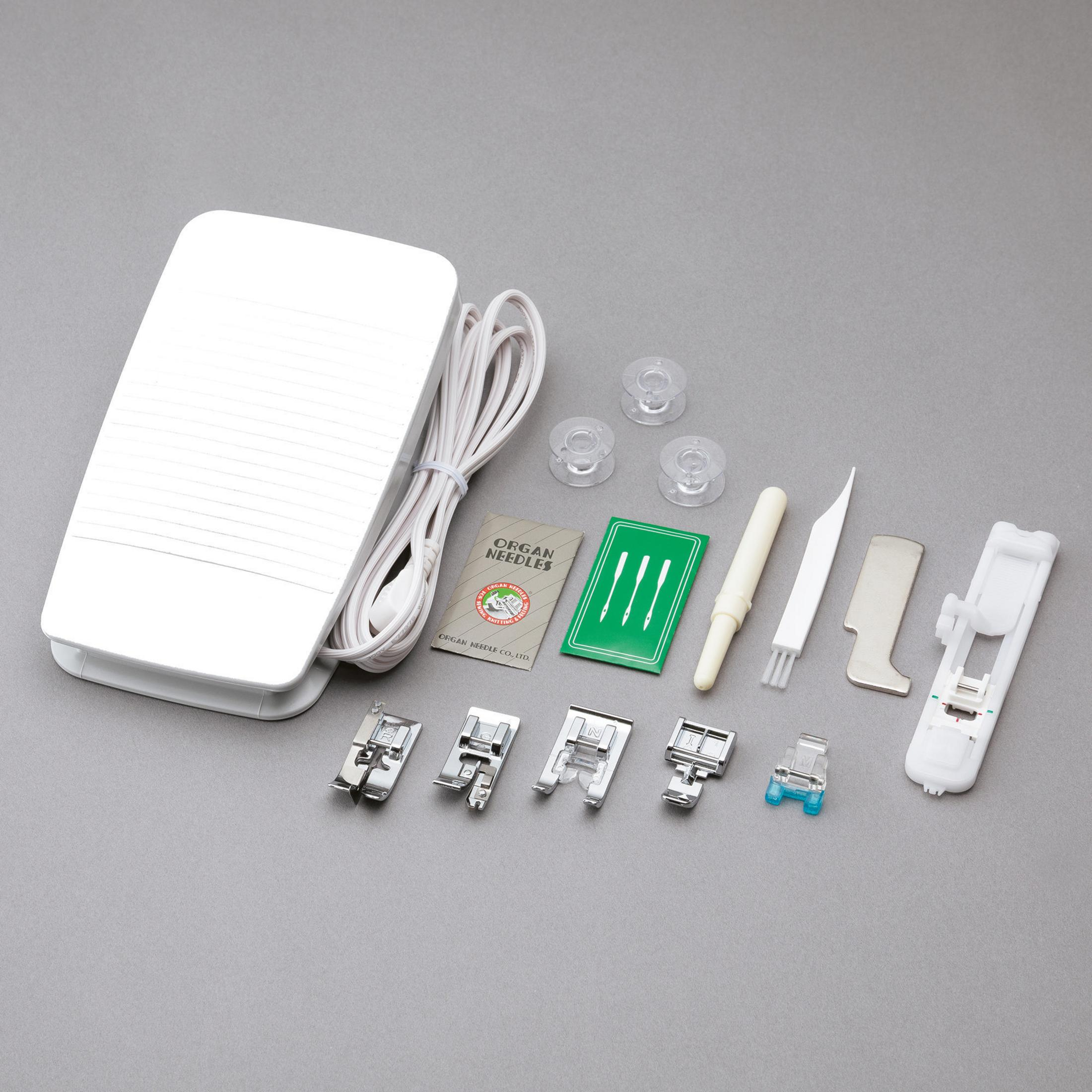 Akcesoria do maszyny do szycia rozłożone na szarej powierzchni. Zawiera pedał, szpulki, igły i różne stopki.