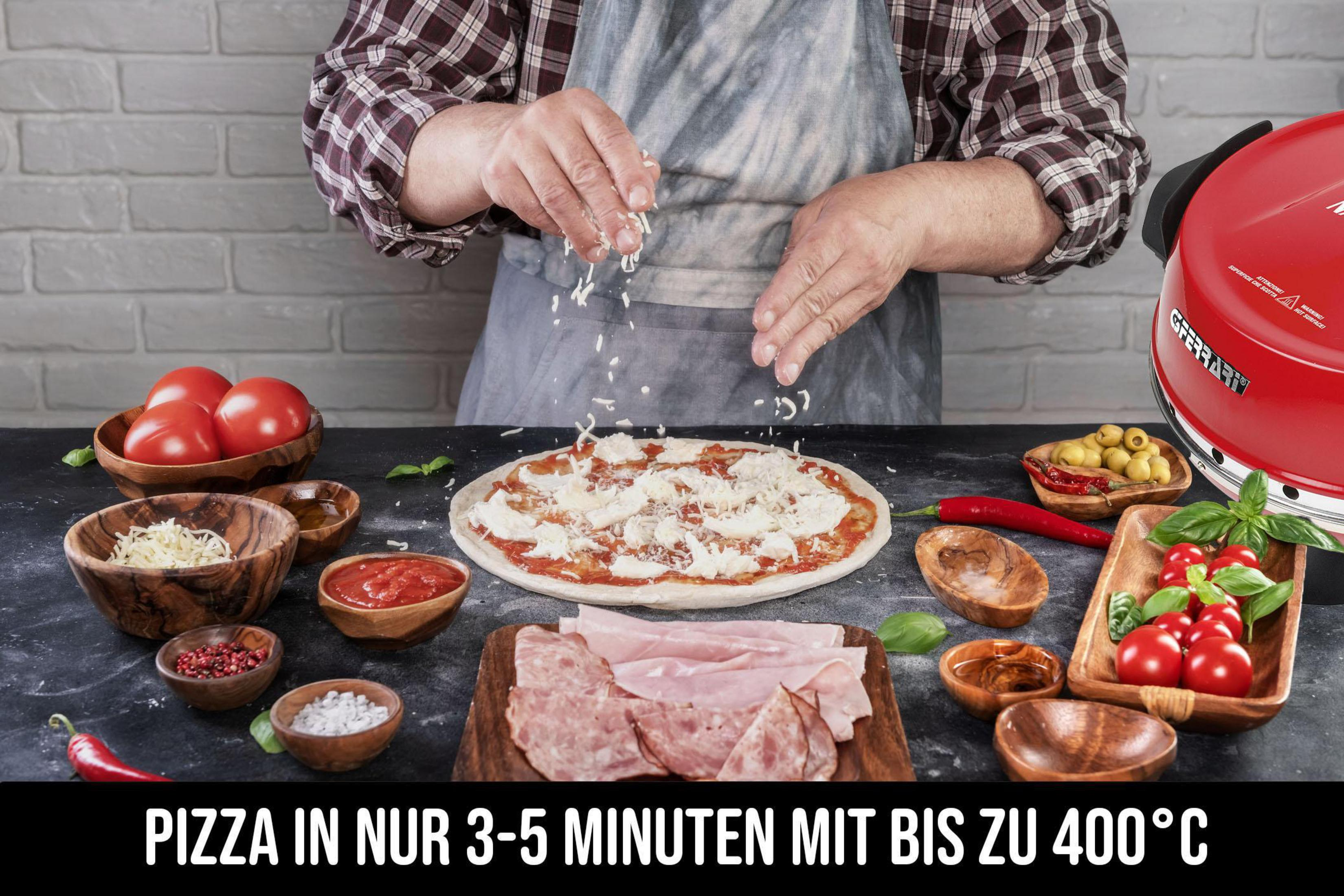 Una persona espolvorea queso sobre pizza con tomate, jamón y salsas.