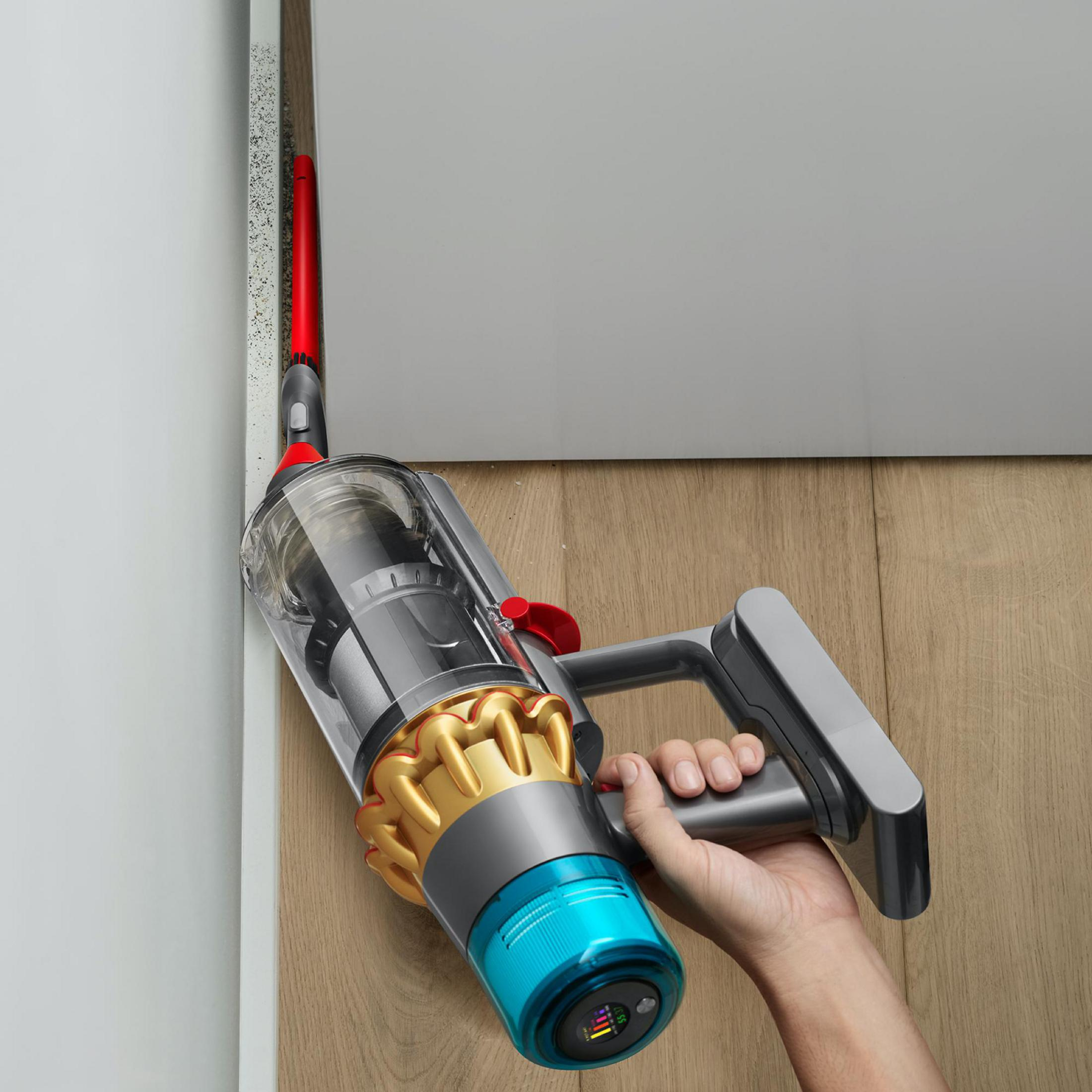 Odkurzacz ręczny czyszczący róg. Odkurzacz jest szary, z niebieską i złotą dyszą.