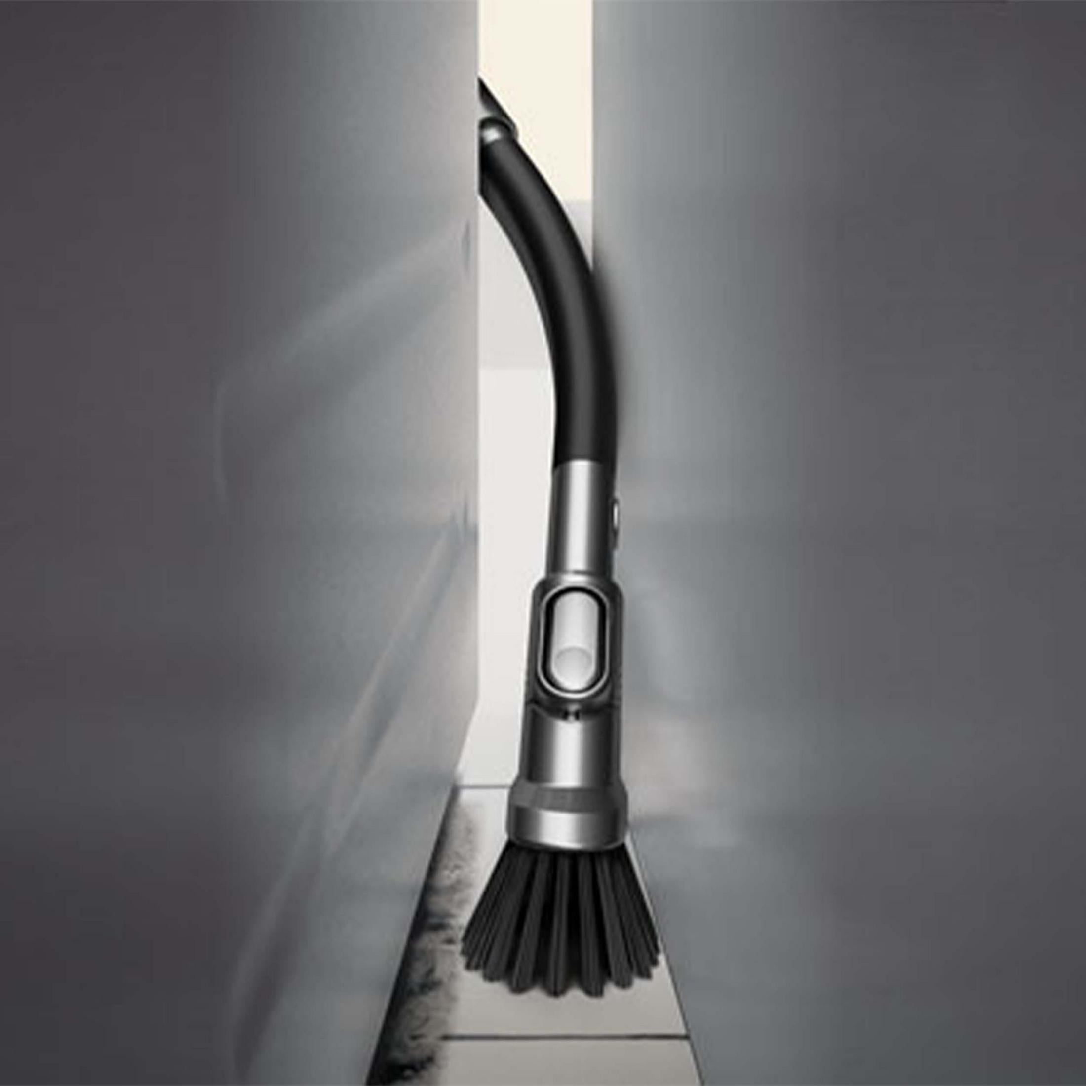 Tête d'aspirateur entre deux murs gris, tuyau noir, tête de brosse.