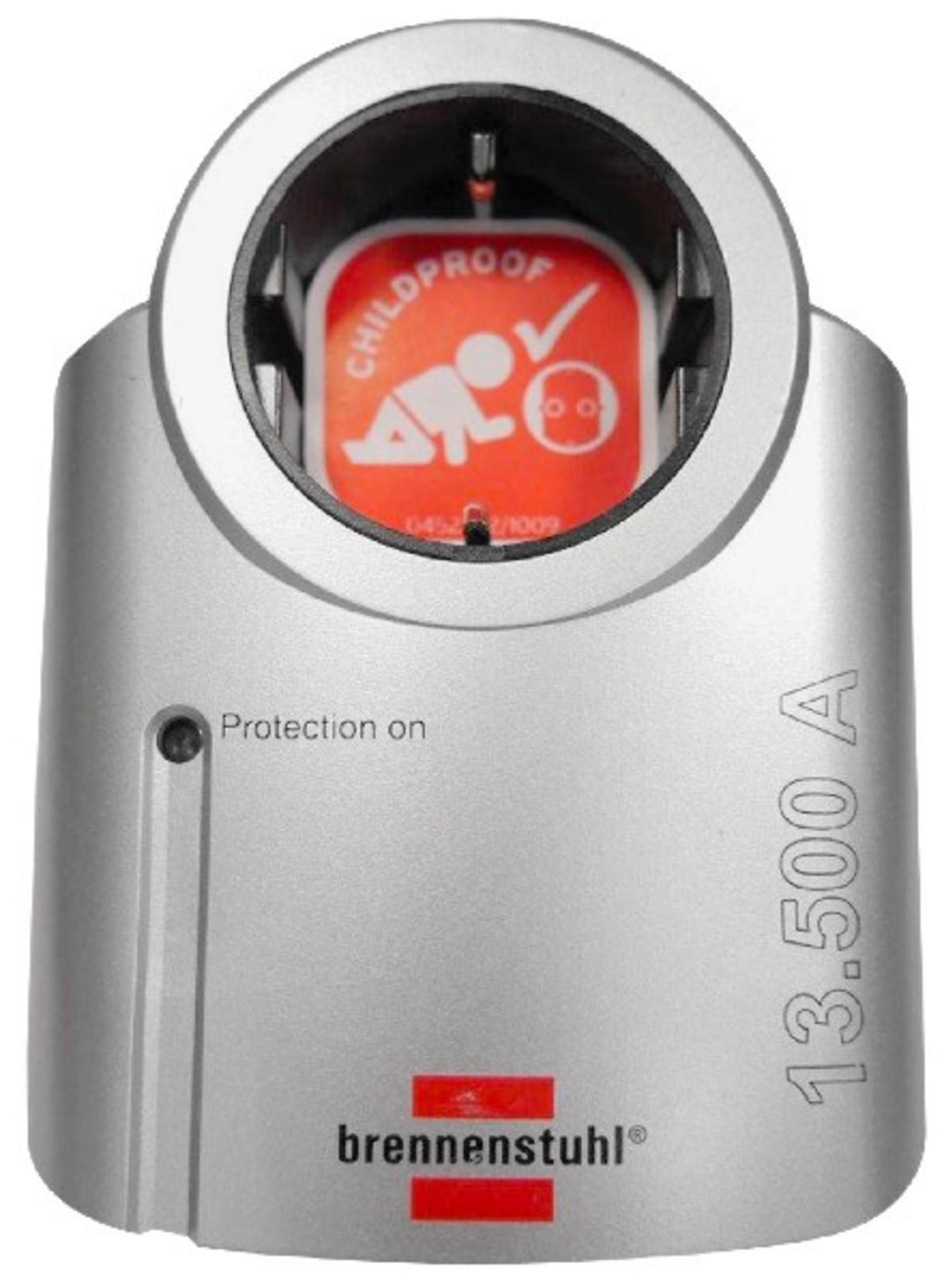 Silberner Steckdosenadapter mit Kindersicherheitsmerkmalen. Rotes Etikett zeigt Kindersicherheits-Symbol und Text.