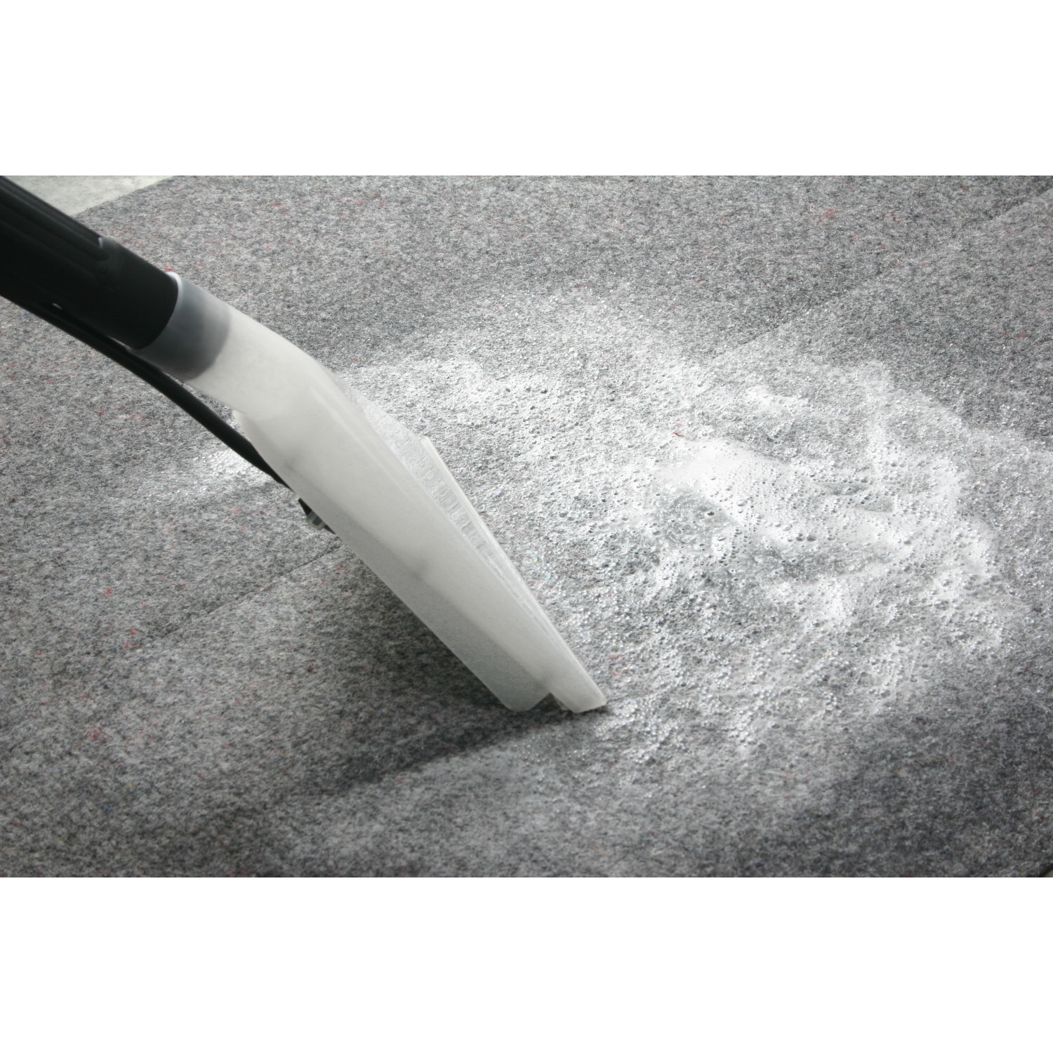 Głowica odkurzacza na szarym dywanie. Proszek czyszczący na dywanie.