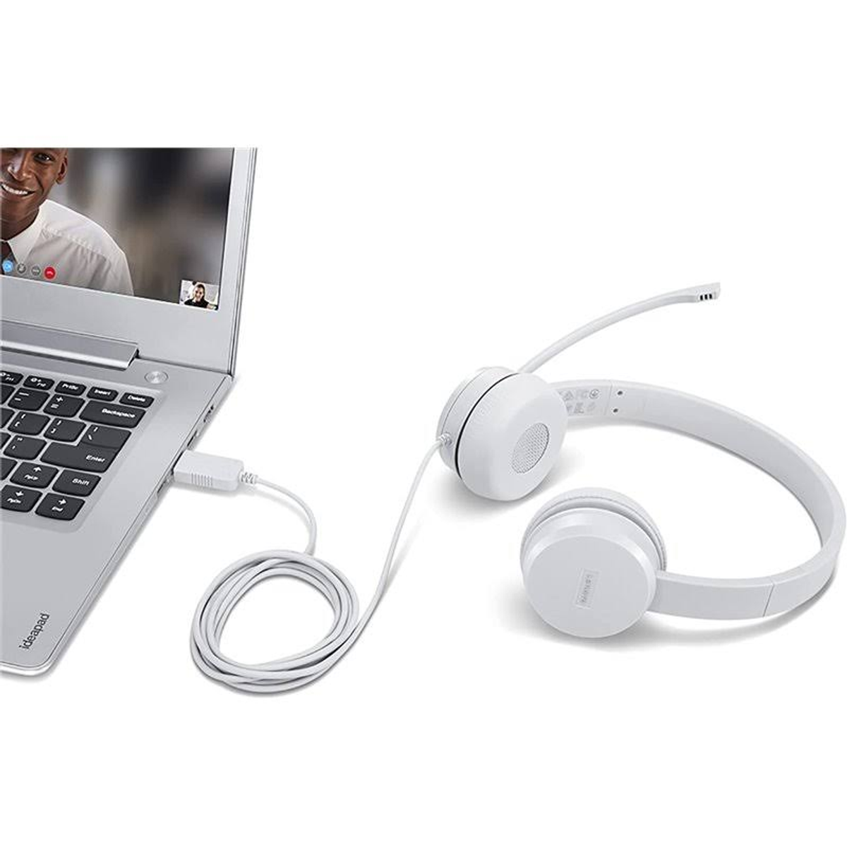 Laptop i biały zestaw słuchawkowy podłączone. Ekran z rozmową wideo. Na białej powierzchni.