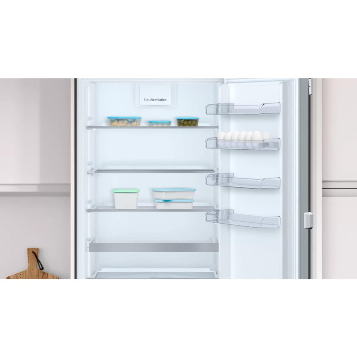 Un refrigerador con la puerta abierta, que muestra estantes con recipientes de alimentos y almacenamiento de huevos.
