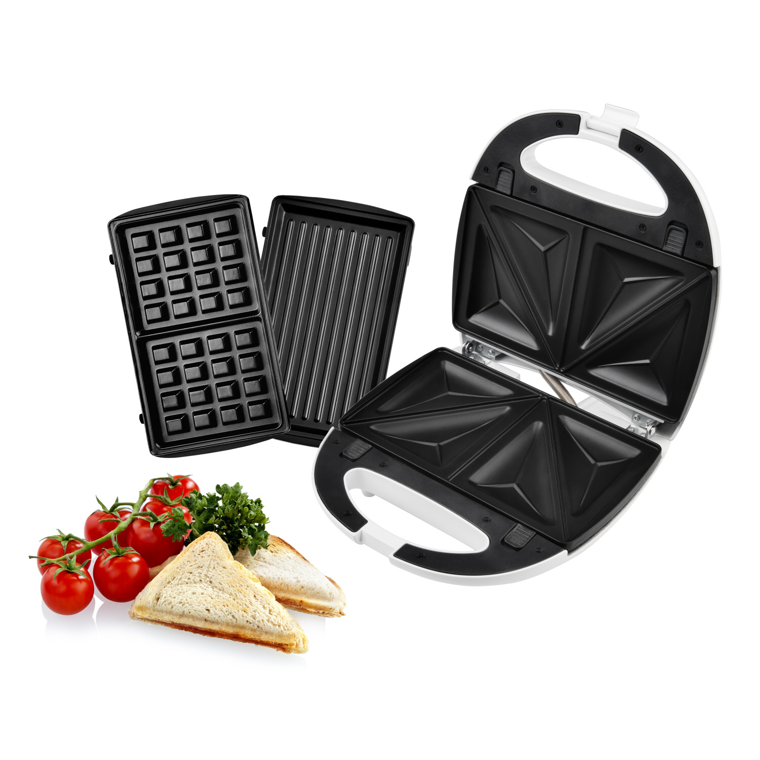 Sandwichmaker mit Waffel- und Grillplatten. Tomaten und Brotscheiben sind vorne.
