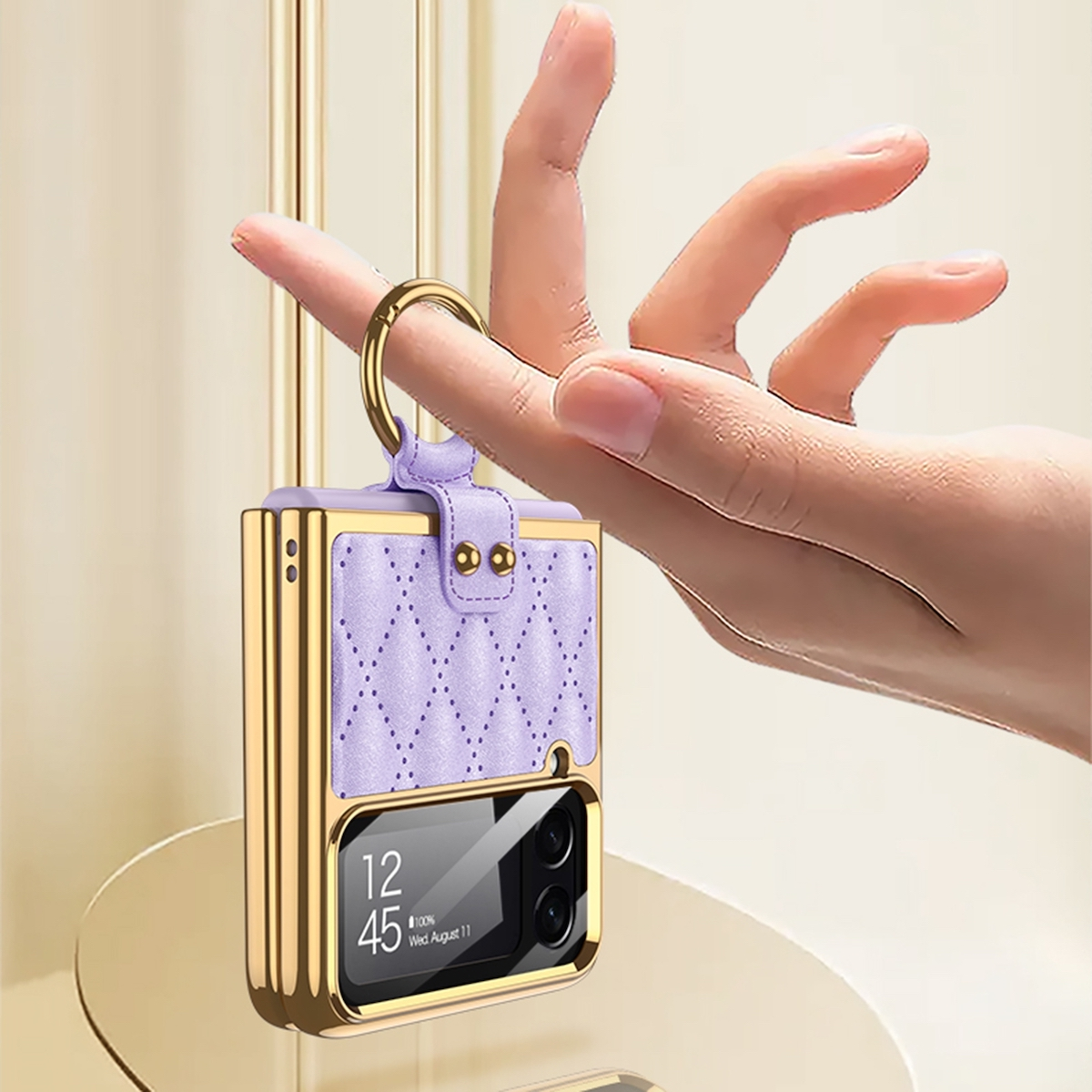 Hand hält eine lila Handyhülle mit goldenem Rahmen und Schlüsselring. Telefonbildschirm sichtbar.