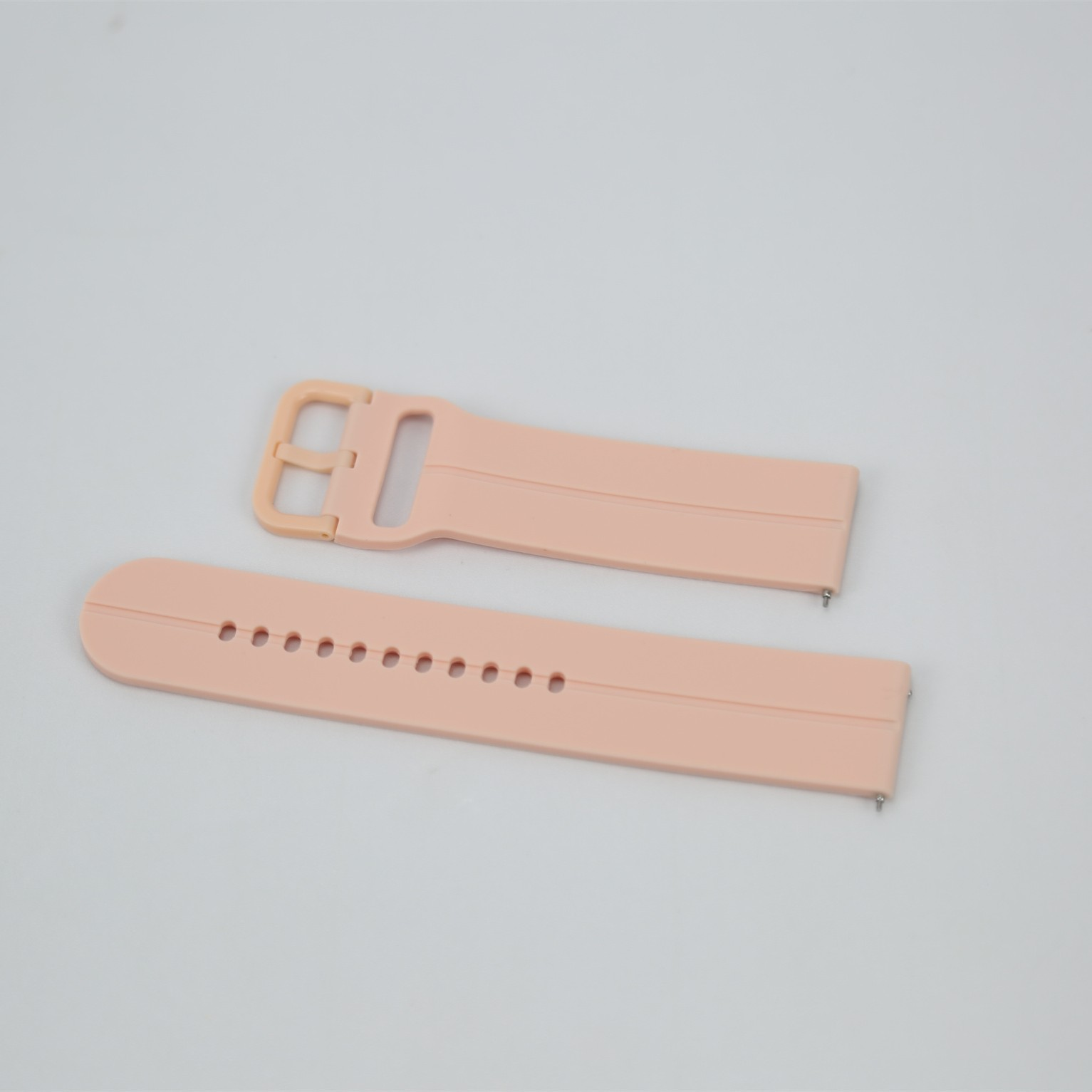 Zwei hellrosa Uhrenarmbänder auf weißem Hintergrund ausgelegt.
