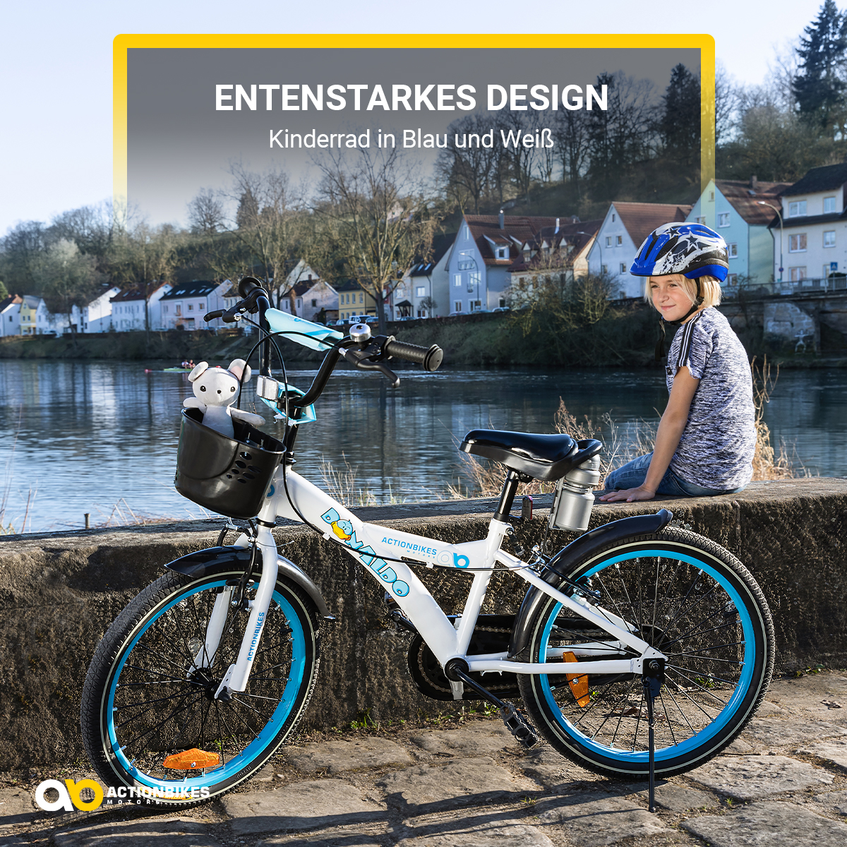 Ein weißes und blaues Kinderfahrrad mit Korb und ein Kind mit Helm sitzt daneben.