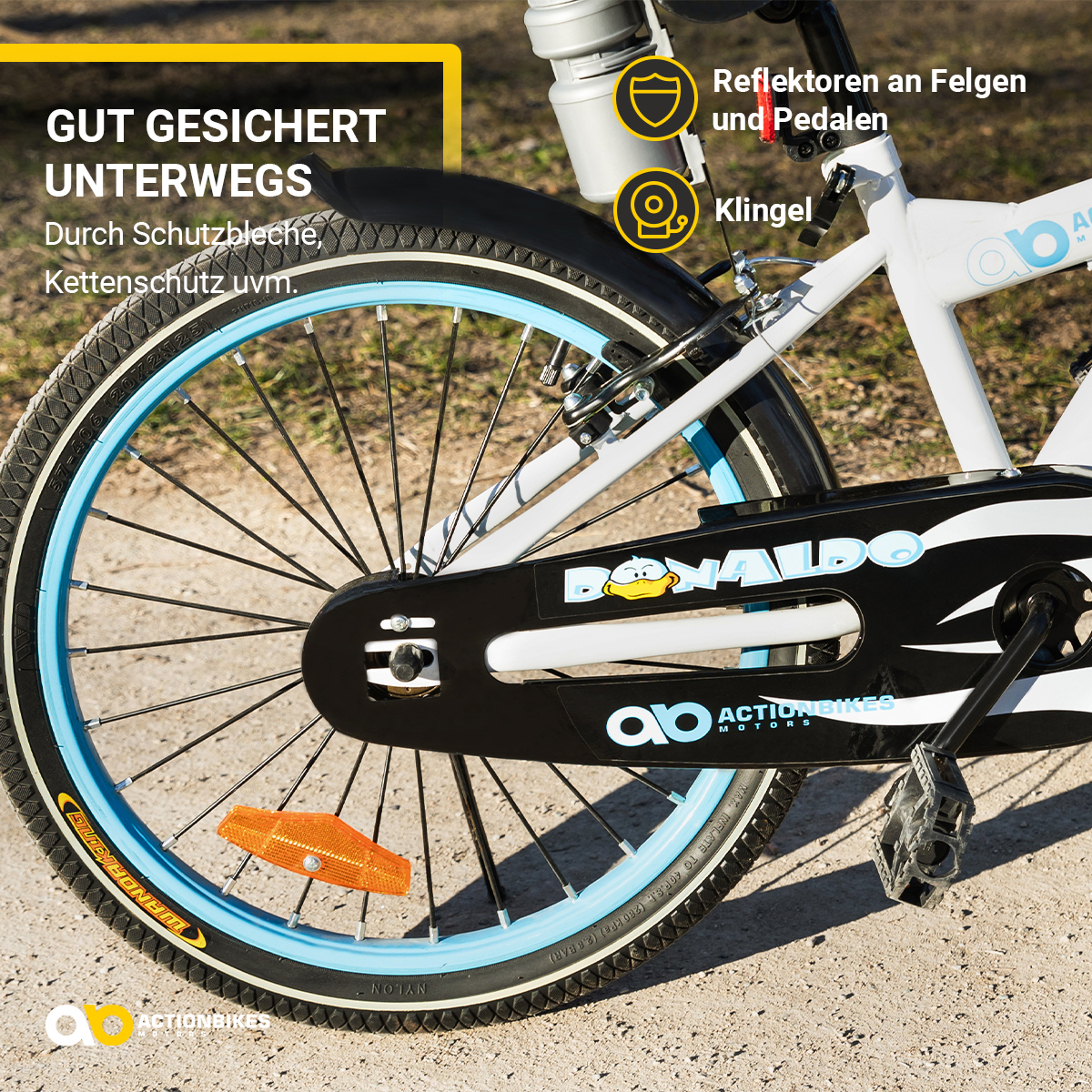 Ein weißes und blaues Fahrradrad mit schwarzem Reifen, orangefarbenem Reflektor und Teil des Fahrrads.