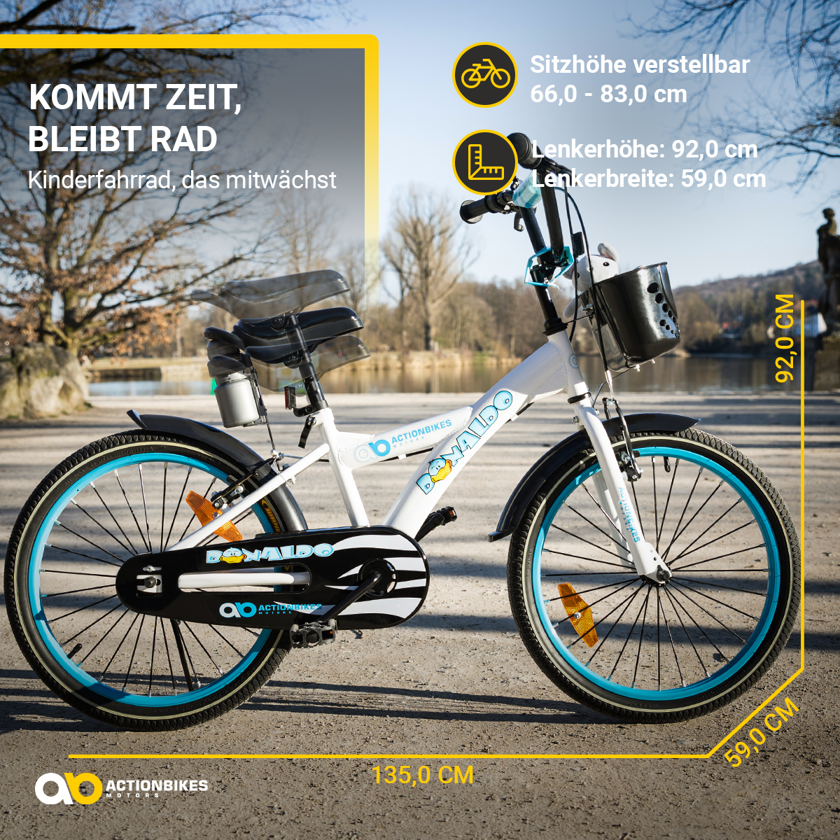 Ein weiß-blaues Kinderfahrrad mit Maßen. Das Fahrrad steht an einem See.