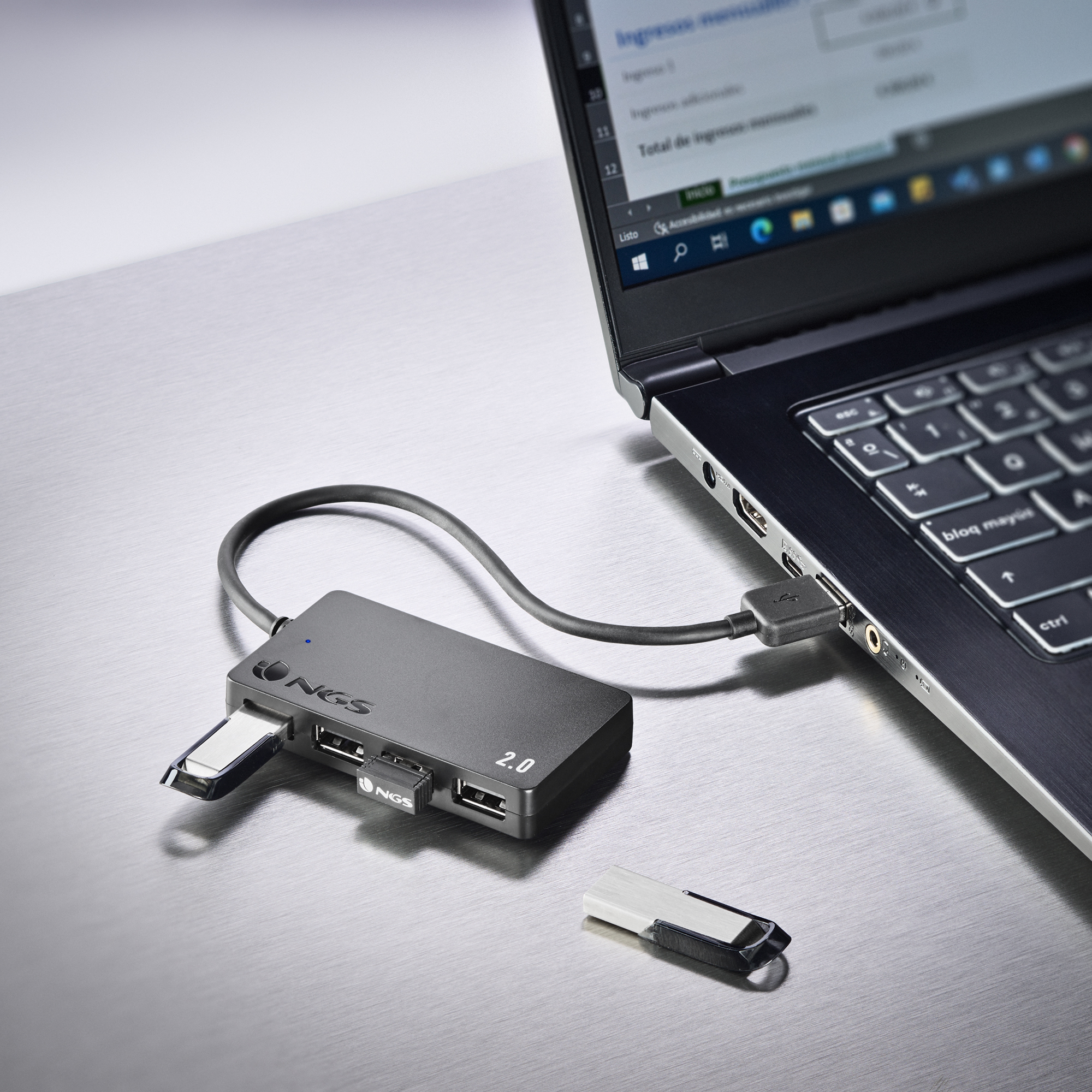 Ein schwarzer USB-Hub, der mit einem Laptop verbunden ist, mit eingestecktem USB-Laufwerk.