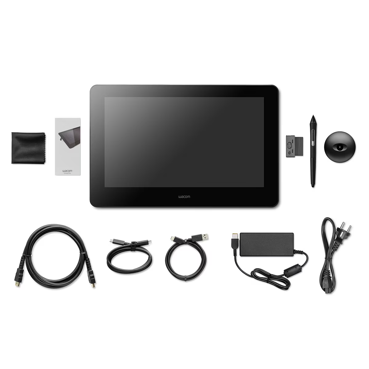 Tablet graficzny z akcesoriami: pióro, zasilacz, kable i ściereczka do czyszczenia, ułożone na białej powierzchni.