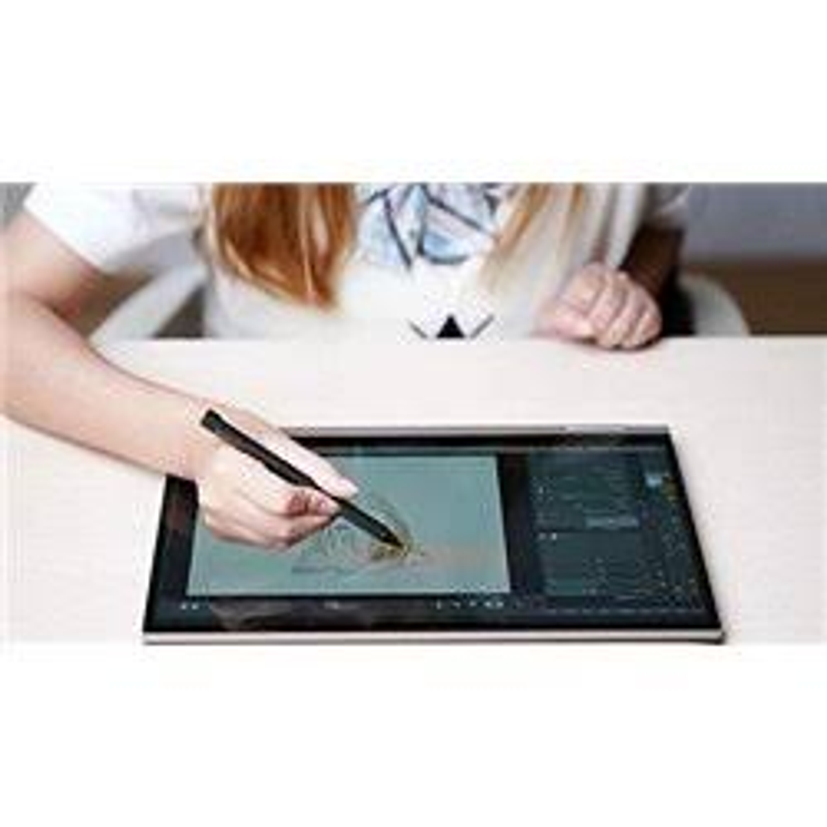 Eine Person benutzt einen Stift auf einem digitalen Tablet, zeichnet. Weißer Tisch.