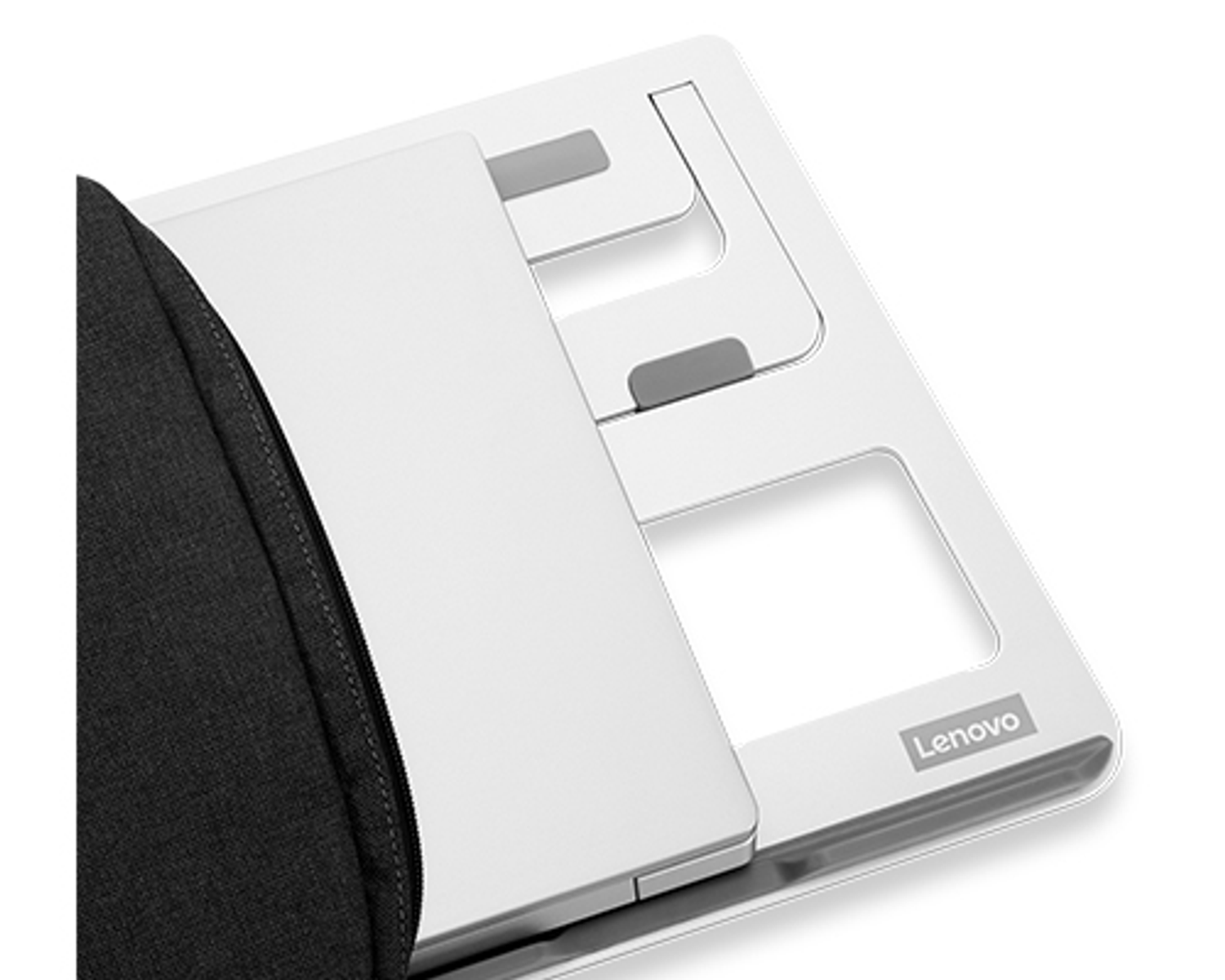 Una laptop plateada en un soporte blanco. Una funda negra cubre parcialmente la laptop.