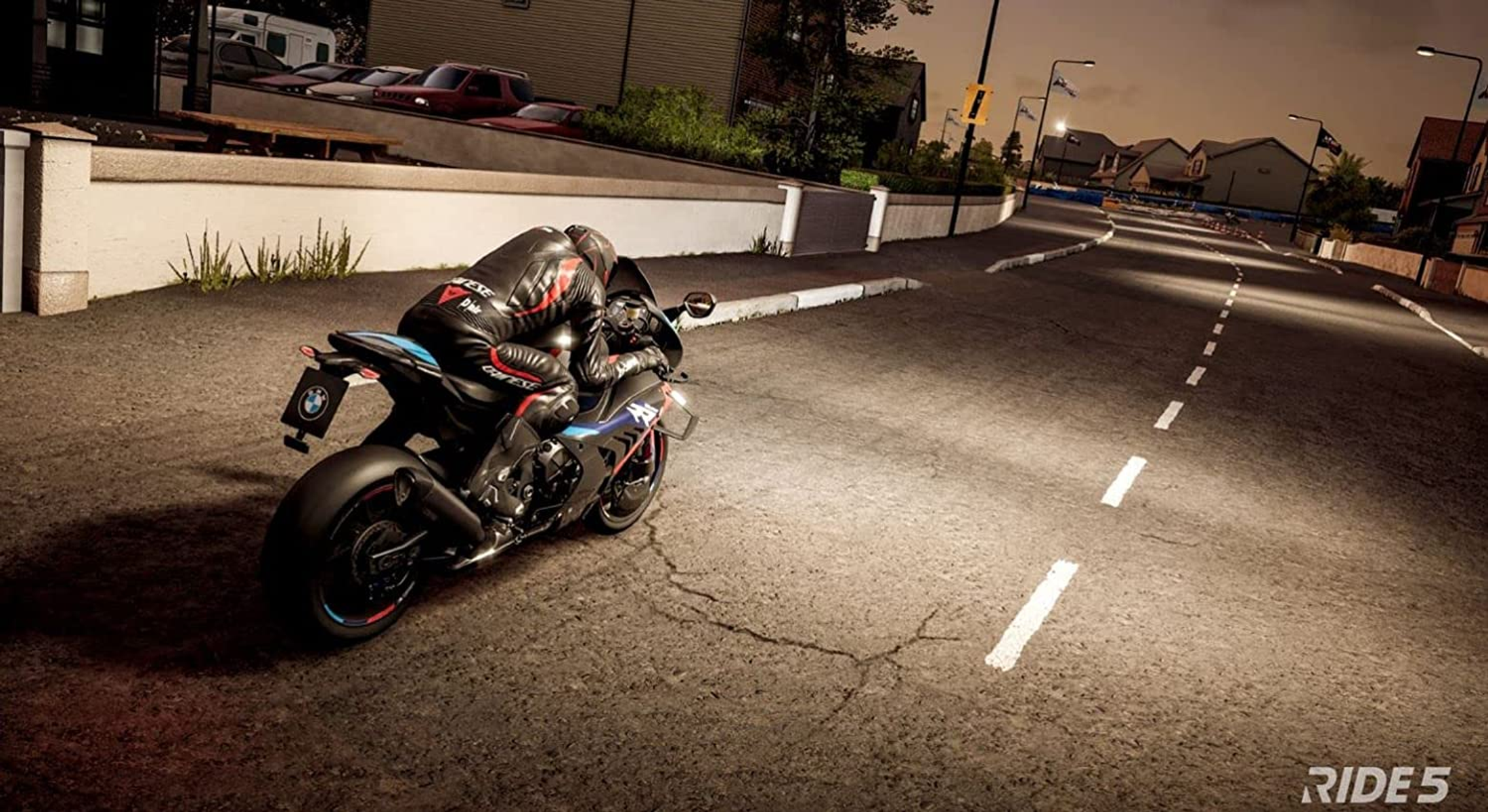 Un motociclista en una moto negra y azul conduce por una carretera asfaltada de noche.