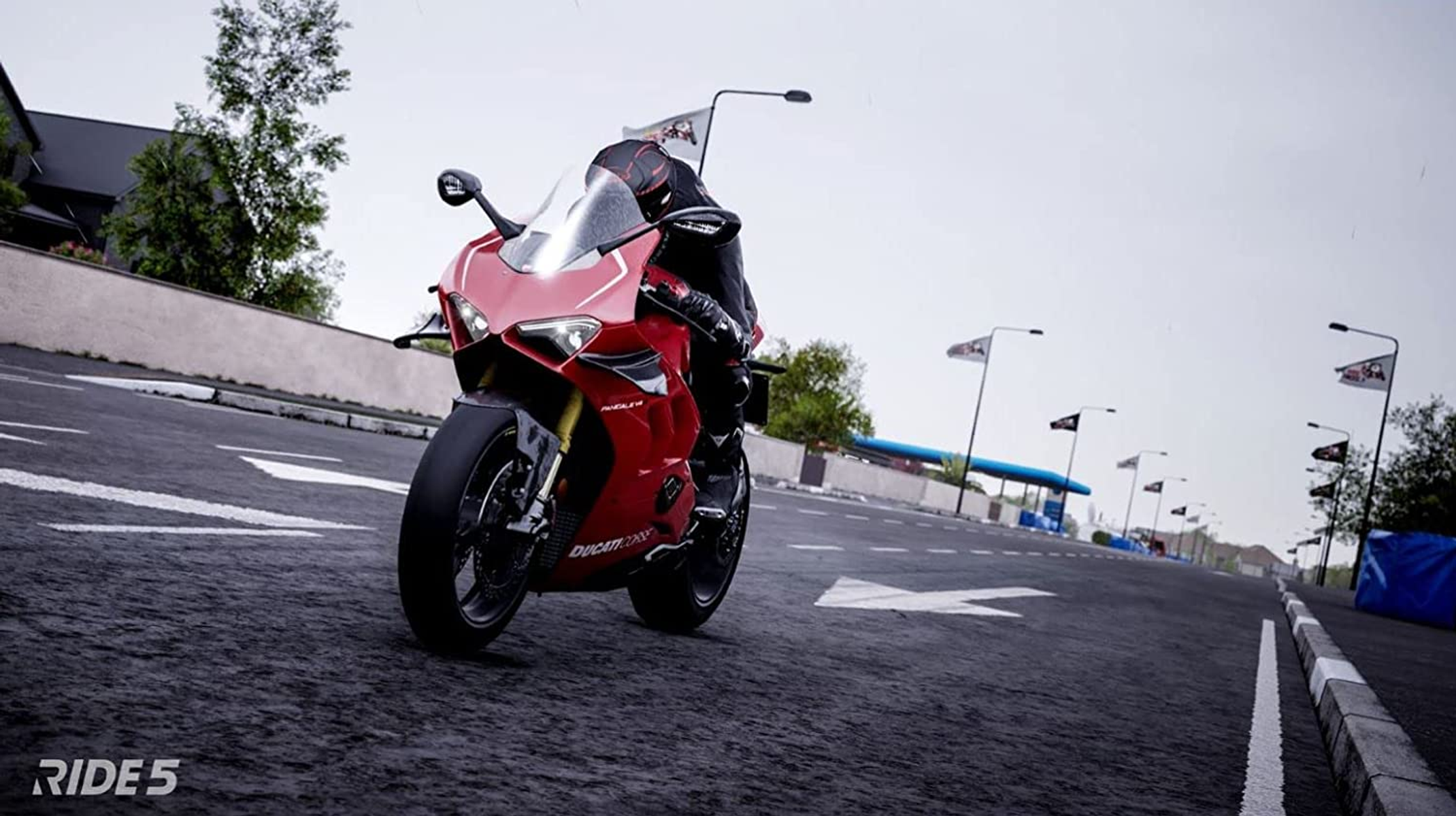 Una motocicleta roja en una carretera. Una persona la está conduciendo. Las palabras RIDE 5 están abajo a la izquierda.