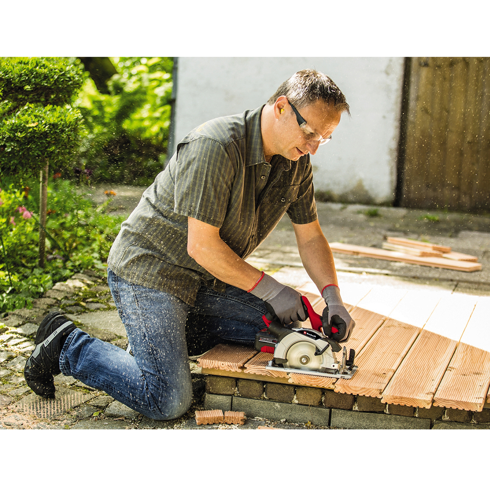 Mężczyzna tnący drewno piłą tarczową.