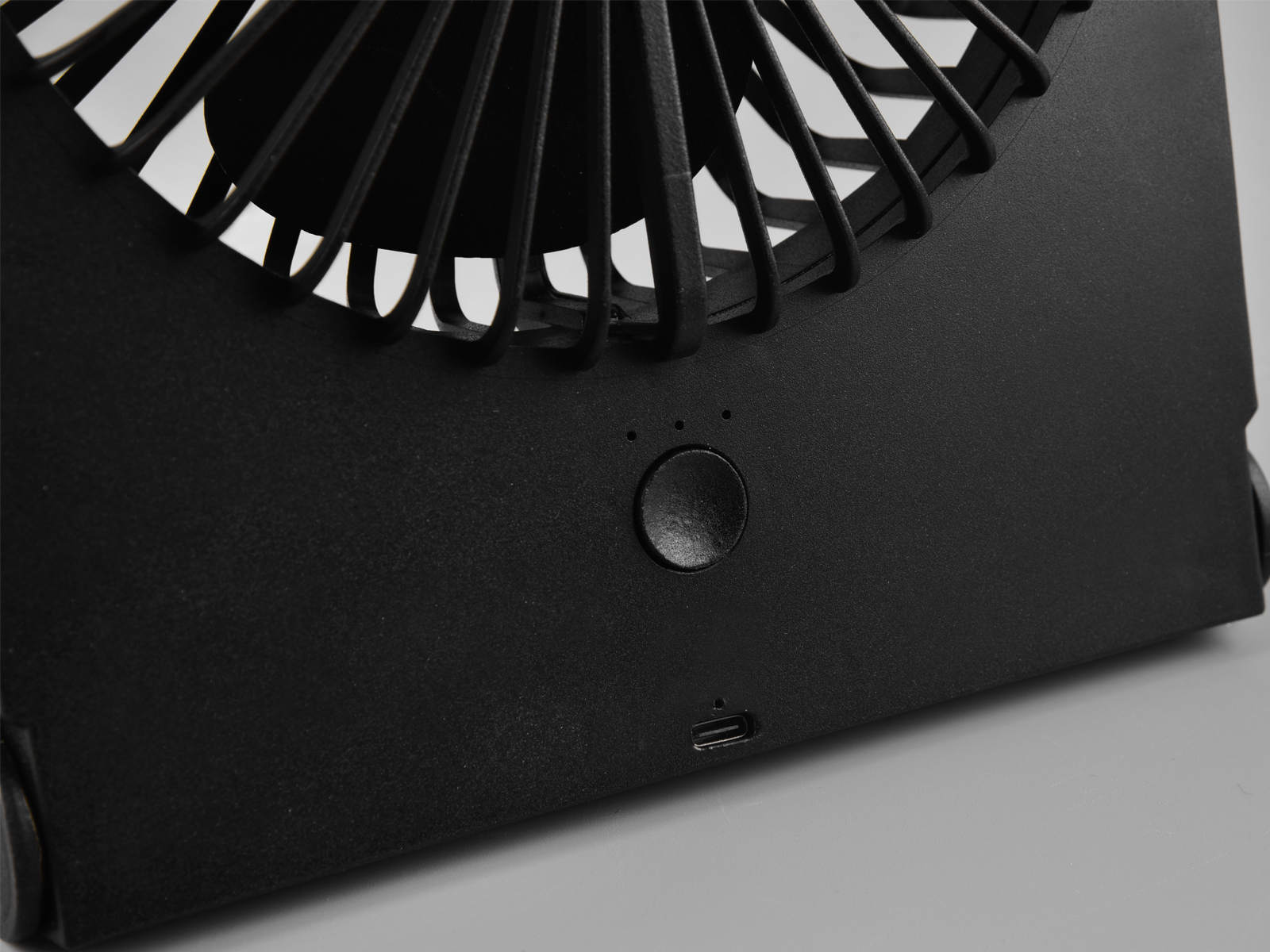 Schwarzer tragbarer Ventilator mit Ein-/Ausschalter und USB-Anschluss. Lüfterblätter sind sichtbar.