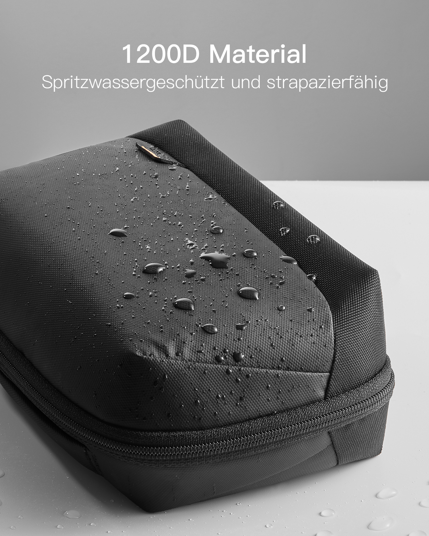 Eine schwarze rechteckige Hülle mit Reißverschluss, mit Wassertropfen auf der Oberfläche.