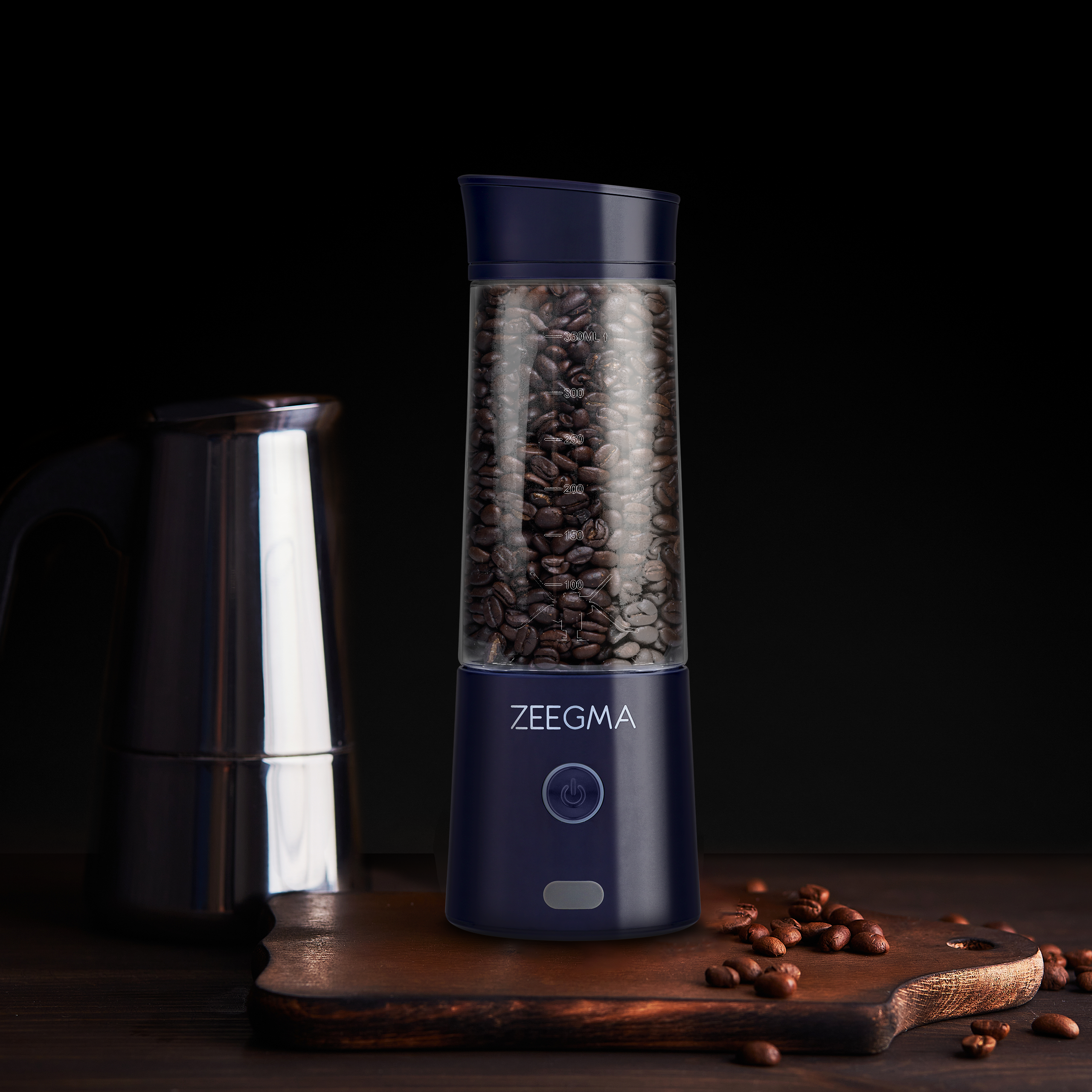 Ziarna kawy w przezroczystym pojemniku, z młynkiem i ciemnym tłem.