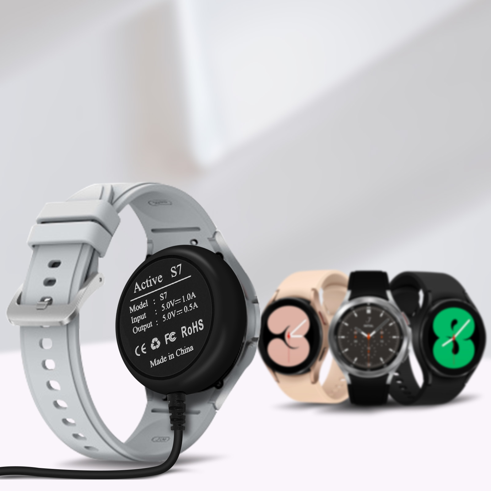 Una stazione di ricarica per smartwatch con cinturino bianco e altri 3 smartwatch sullo sfondo.