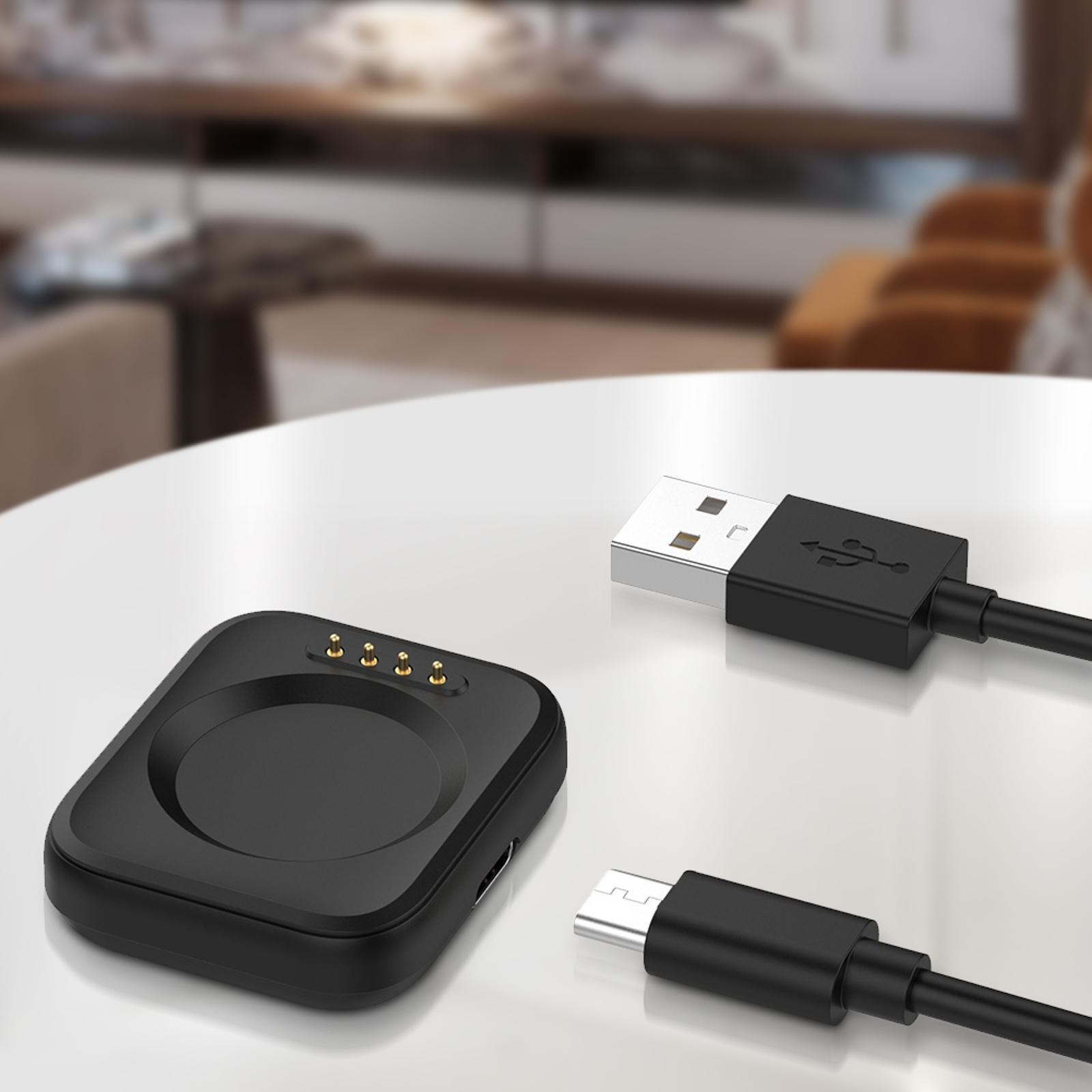 Base di ricarica nera e cavi USB su sfondo sfocato.