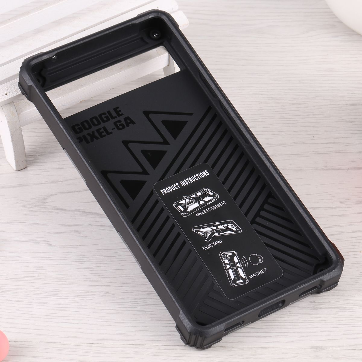 Schwarze Handyhülle mit Produktanleitungskarte. Anweisungen zeigen Ständer, Winkeleinstellung und Magnet.