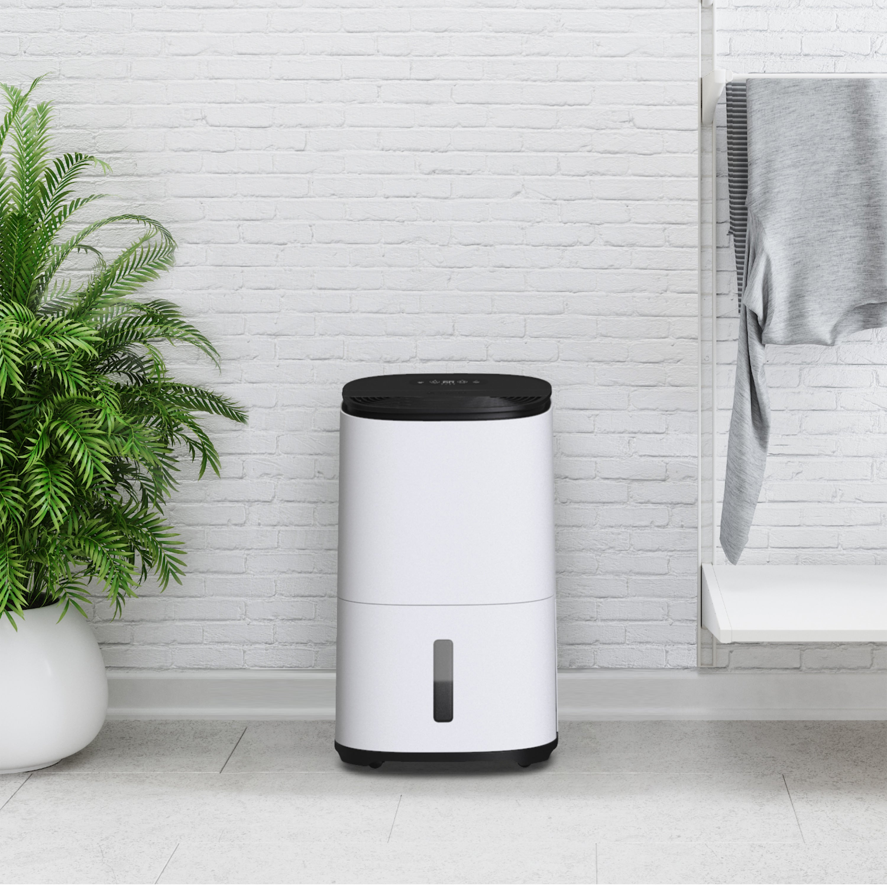 Biały osuszacz powietrza z czarnym blatem i rośliną obok ściany z cegieł.
