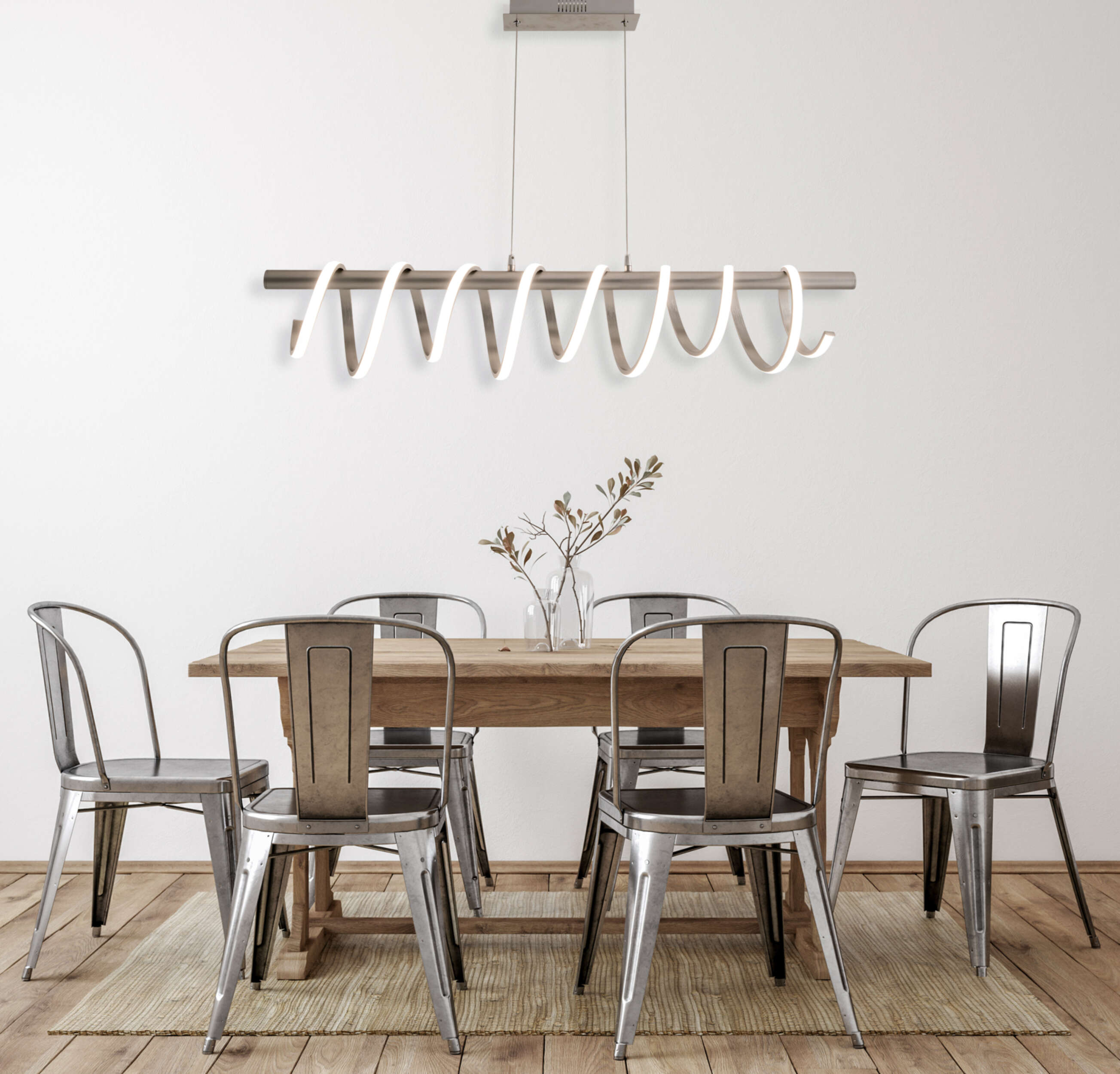Ein Esszimmer mit Holztisch, Metallstühlen und einer spiralförmigen Pendelleuchte an einer weißen Wand.
