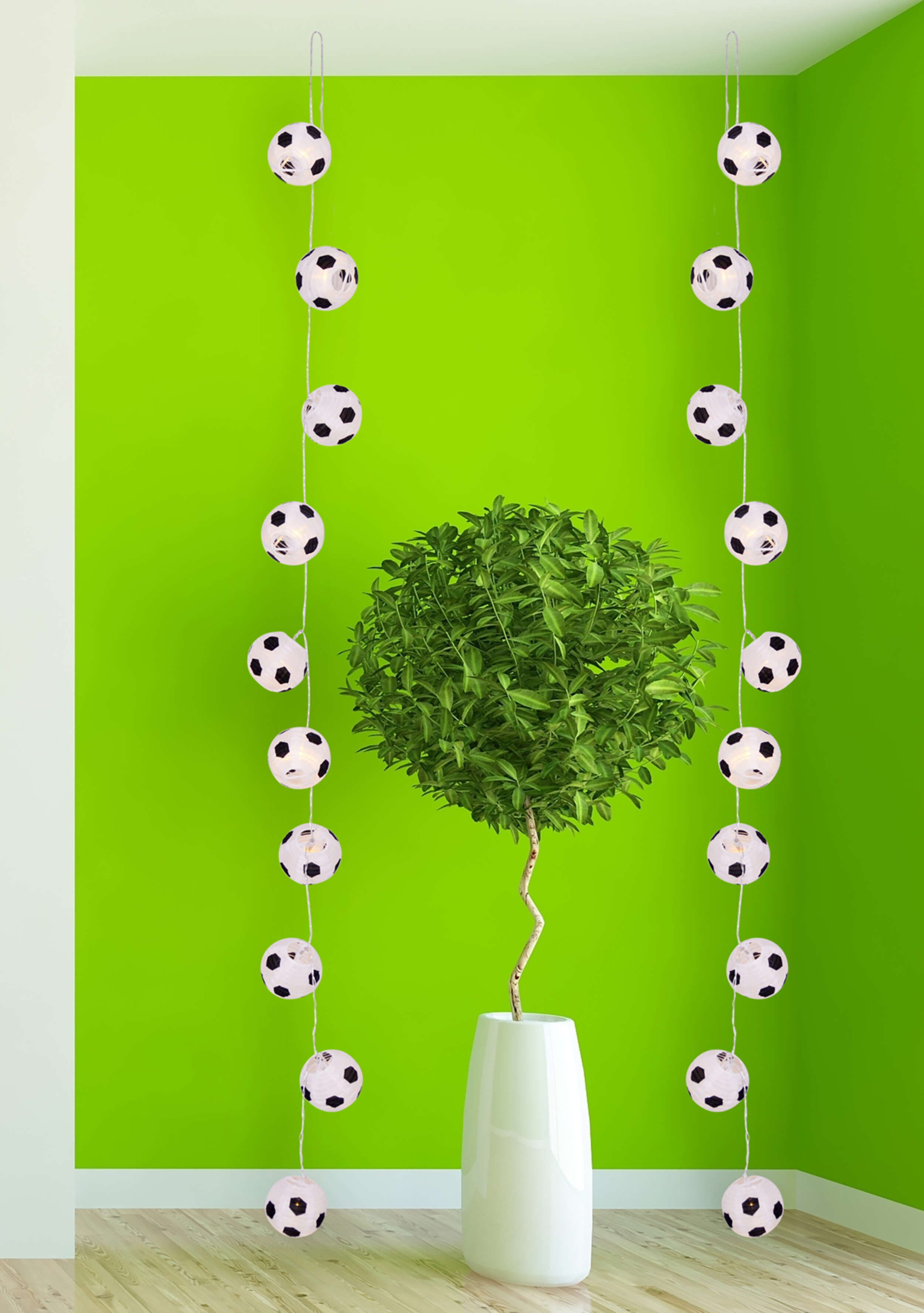 Grüne Wand, weiße Vase mit kleinem Baum und Fußball-Lichtern, die herunterhängen.
