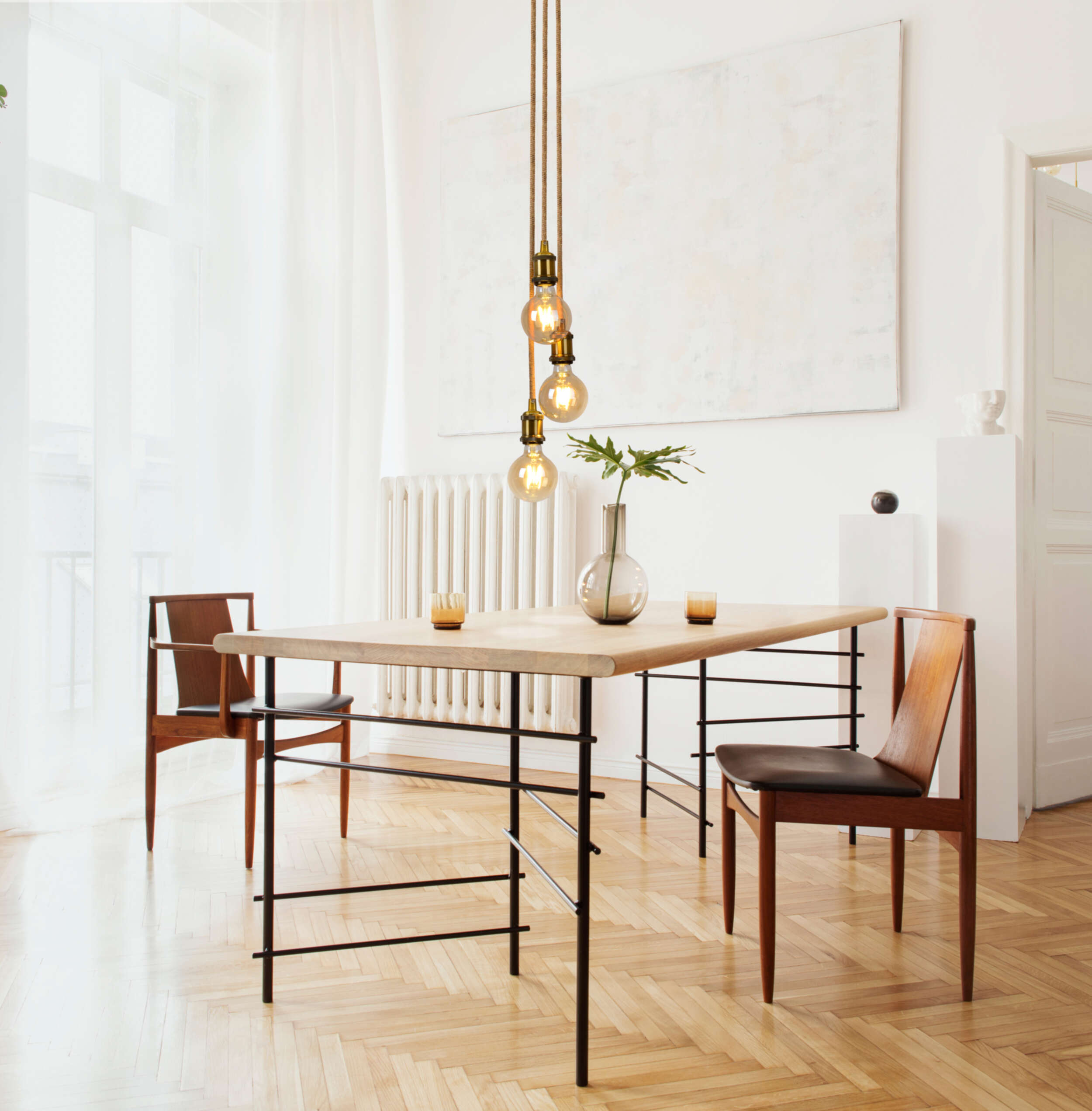 Esszimmer mit Holztisch, Stühlen und einer modernen Hängelampe.