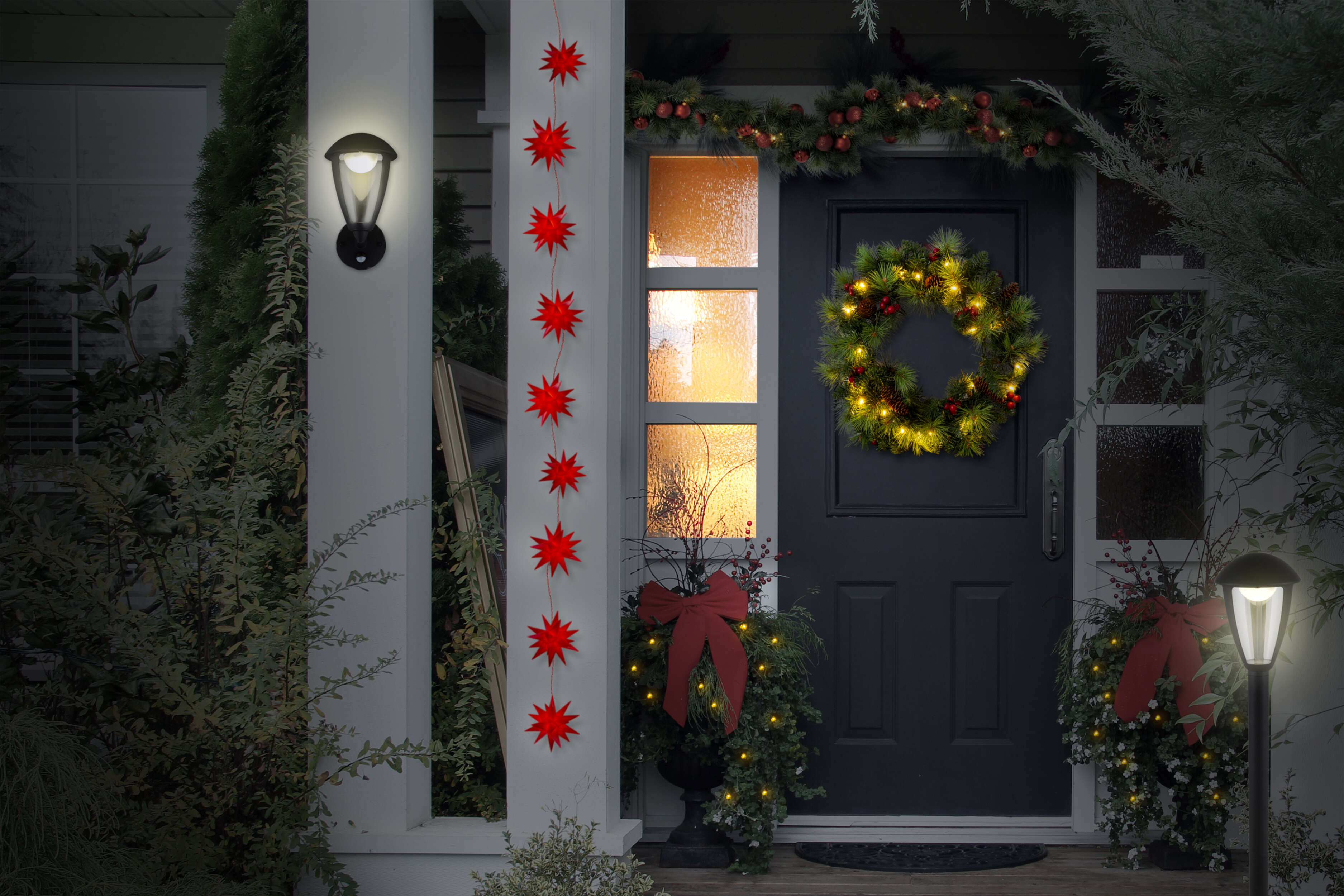 Ein Hauseingang mit Weihnachtsdekorationen, darunter ein Kranz und Sternlichter.