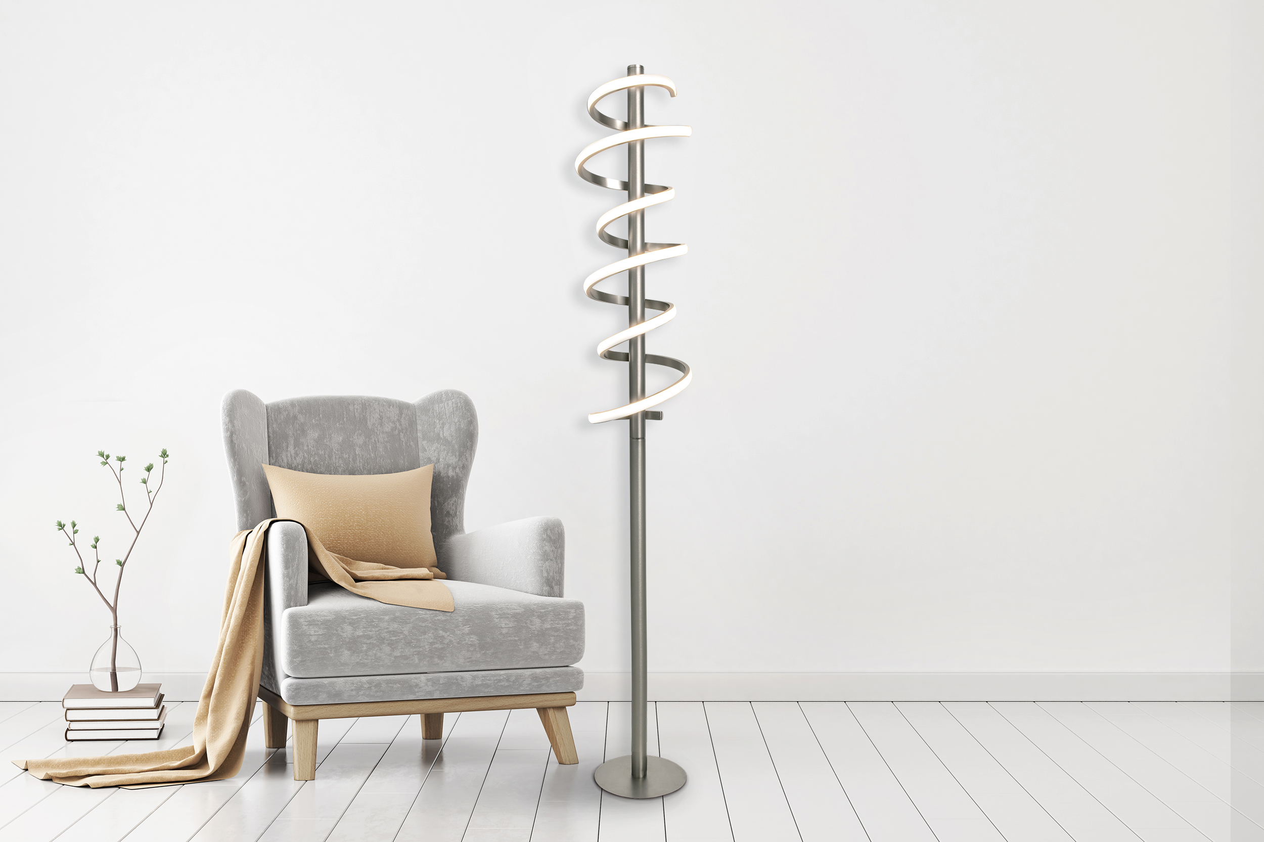 Moderne silberne Spiral-Stehlampe neben einem grauen Sessel mit Kissen und Decke.