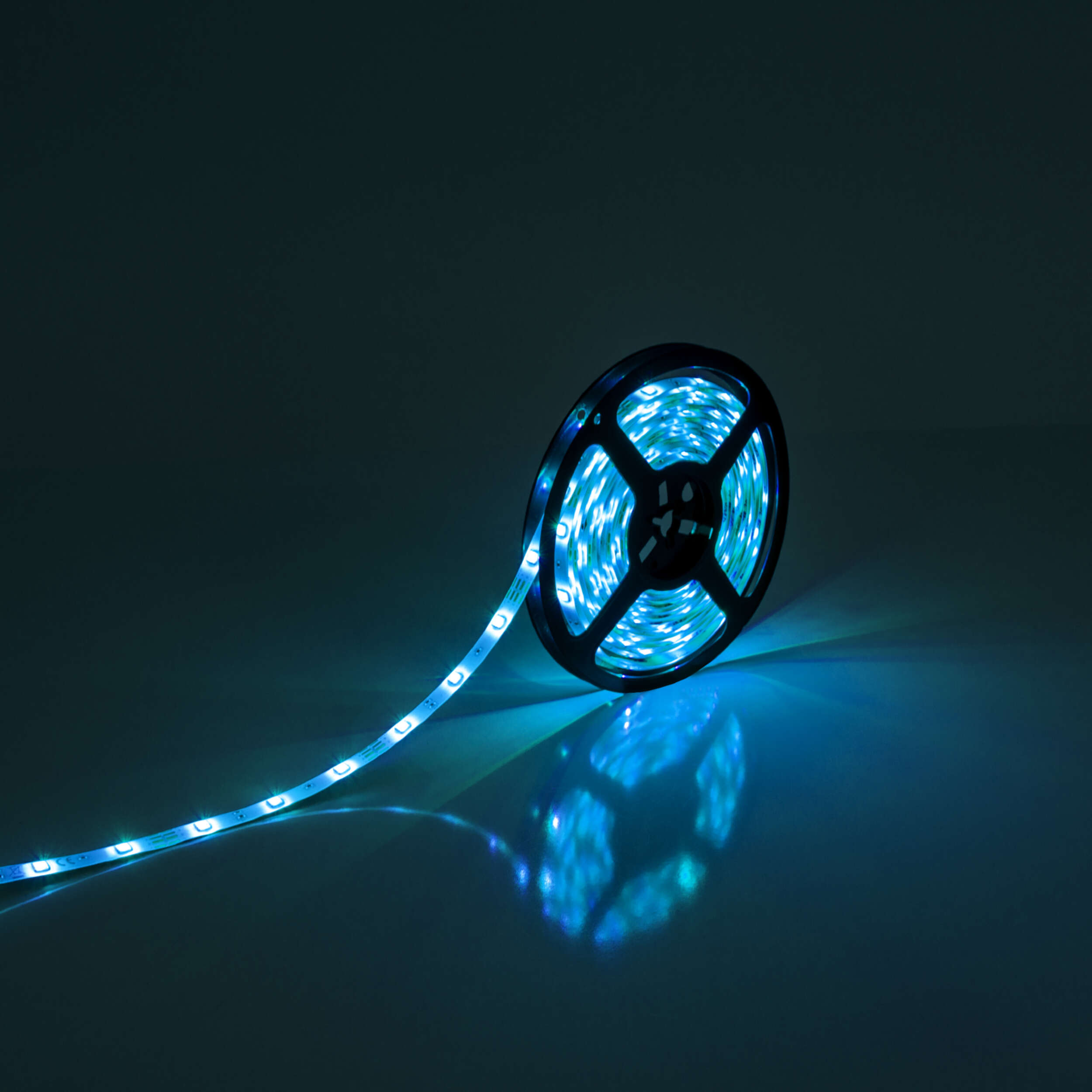 Eine Rolle mit blauen LED-Streifen. Die Lichter emittieren ein blaues Leuchten. Der Hintergrund ist dunkel.