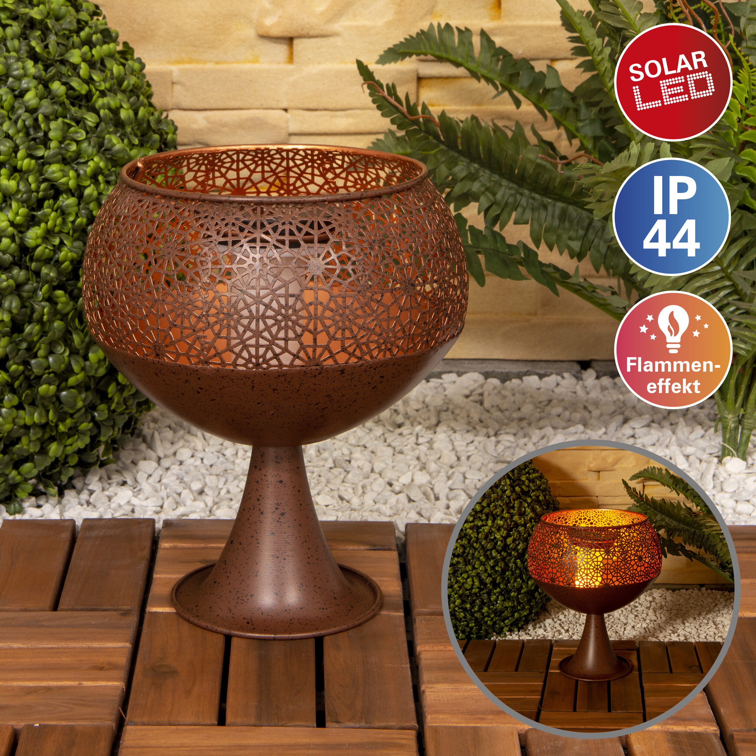 Bronze-Solar-Gartenlampe mit floralem Design, auf Holzdeck mit Pflanzen im Hintergrund.