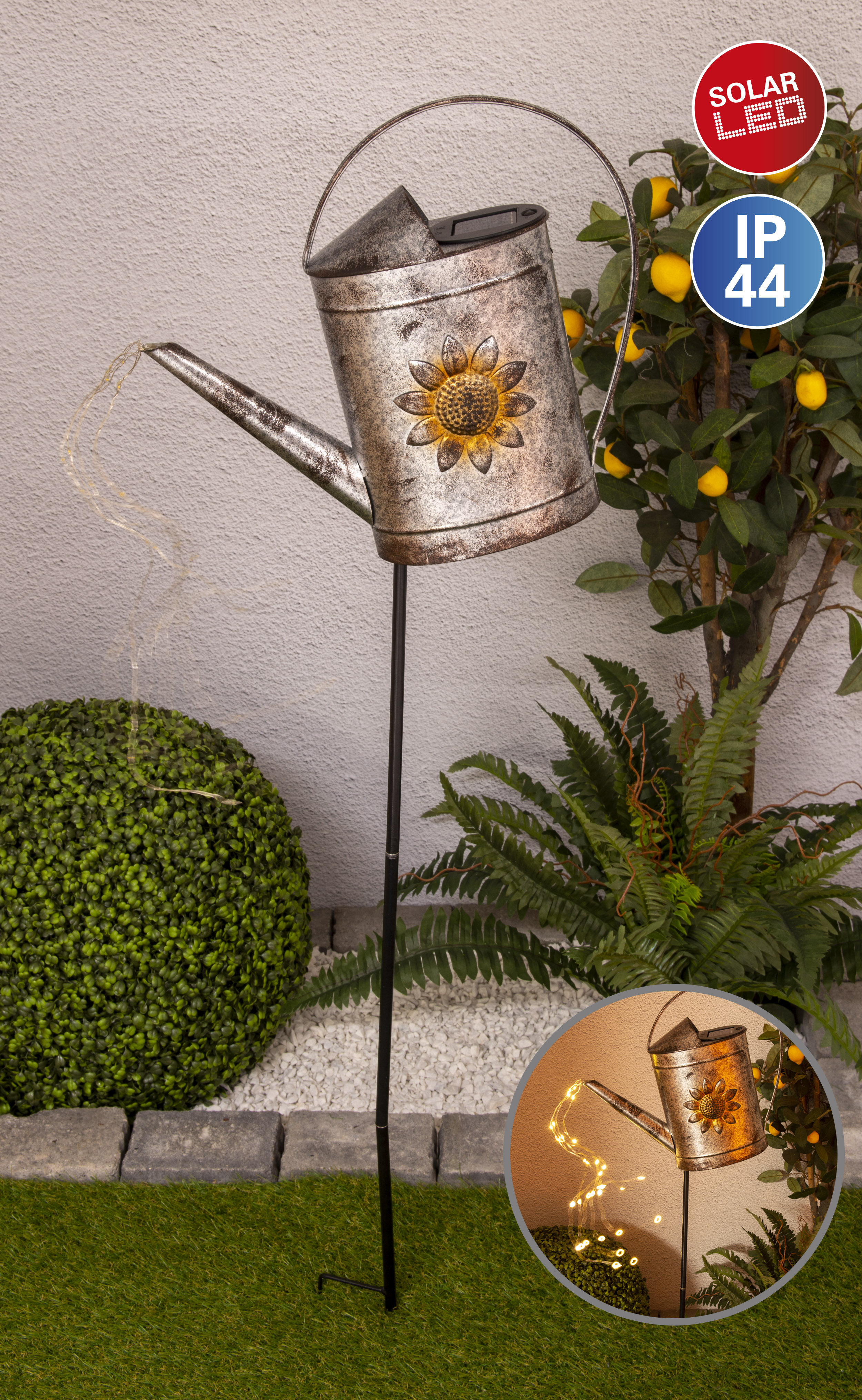 Ein solarbetriebener Gießkannen-Gartenpfahl mit Sonnenblume und Lichterketten.