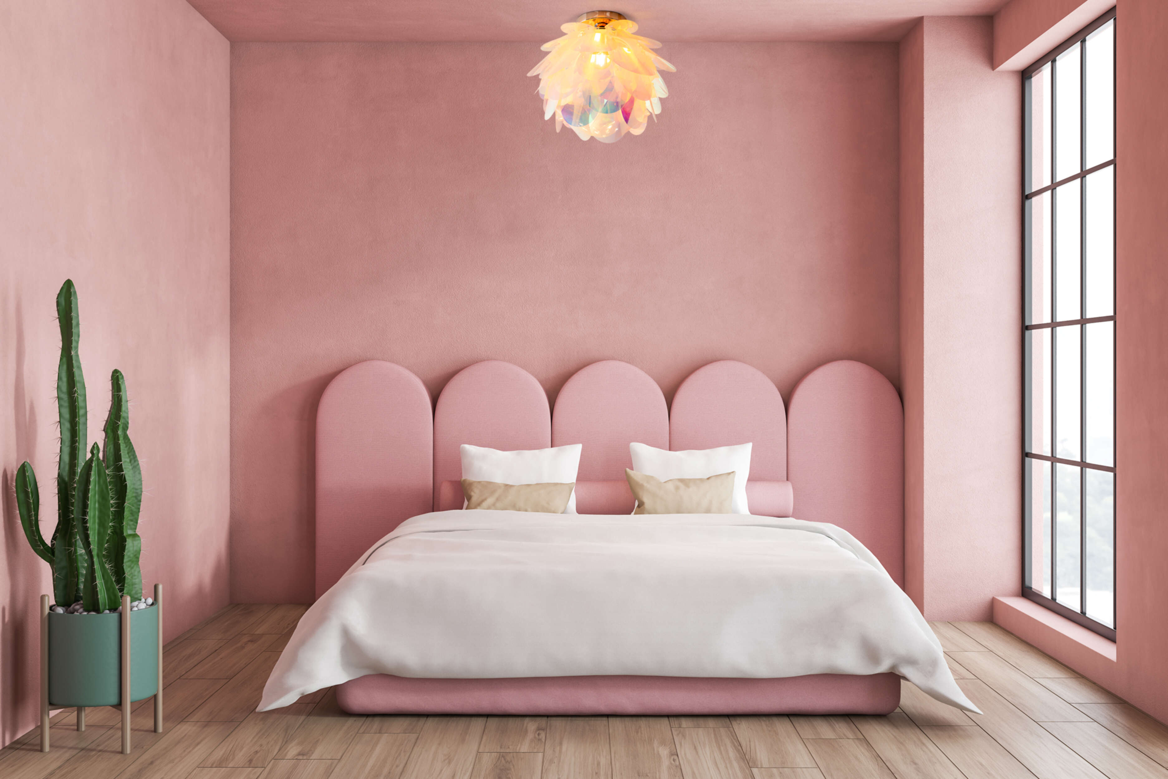 Rosa Schlafzimmer mit Bett, Kaktus und Kronleuchter, rosa Wände und Holzboden.