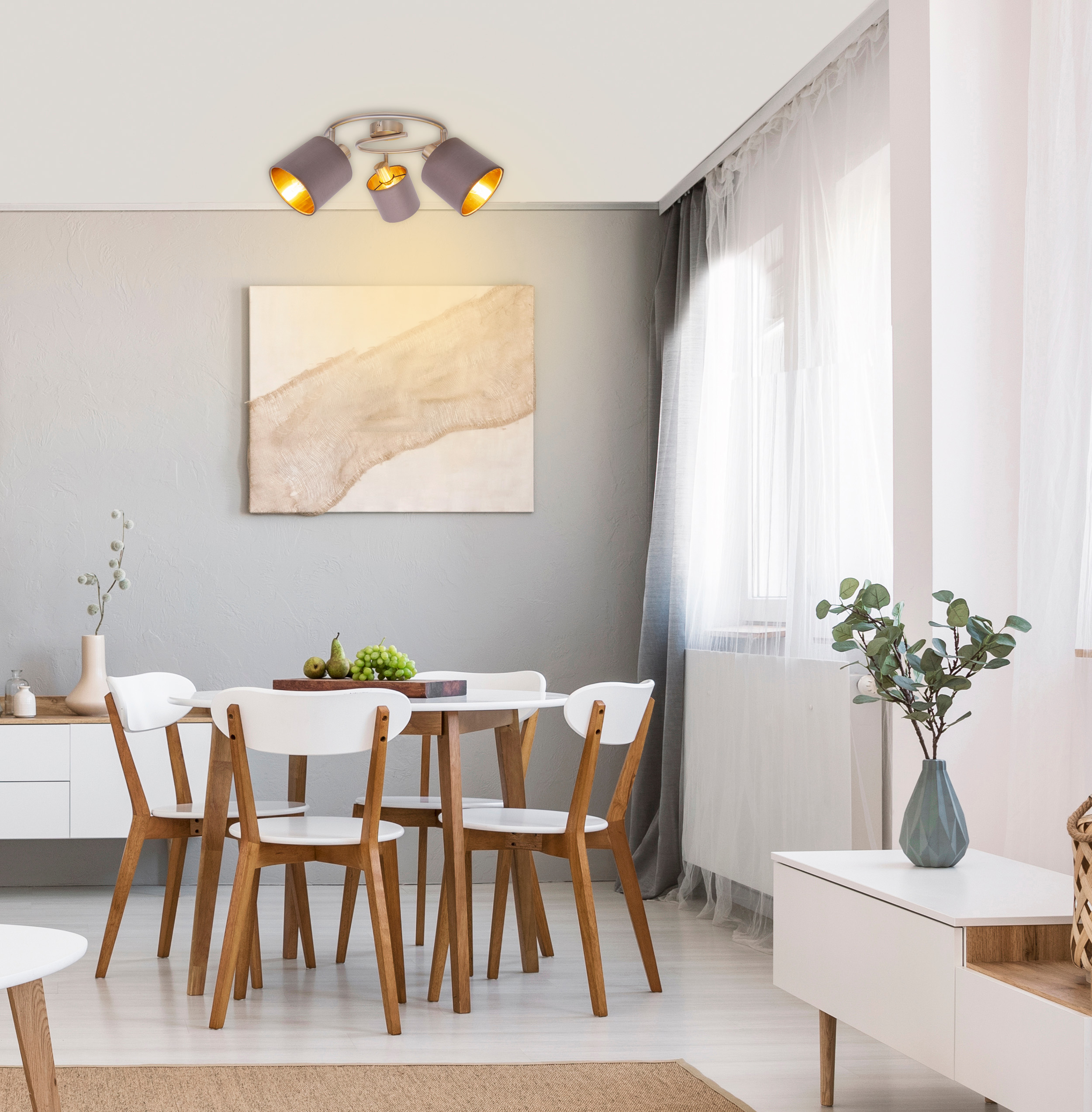 Esszimmer mit rundem Tisch, Stühlen und Deckenleuchte. Gemälde an der Wand.