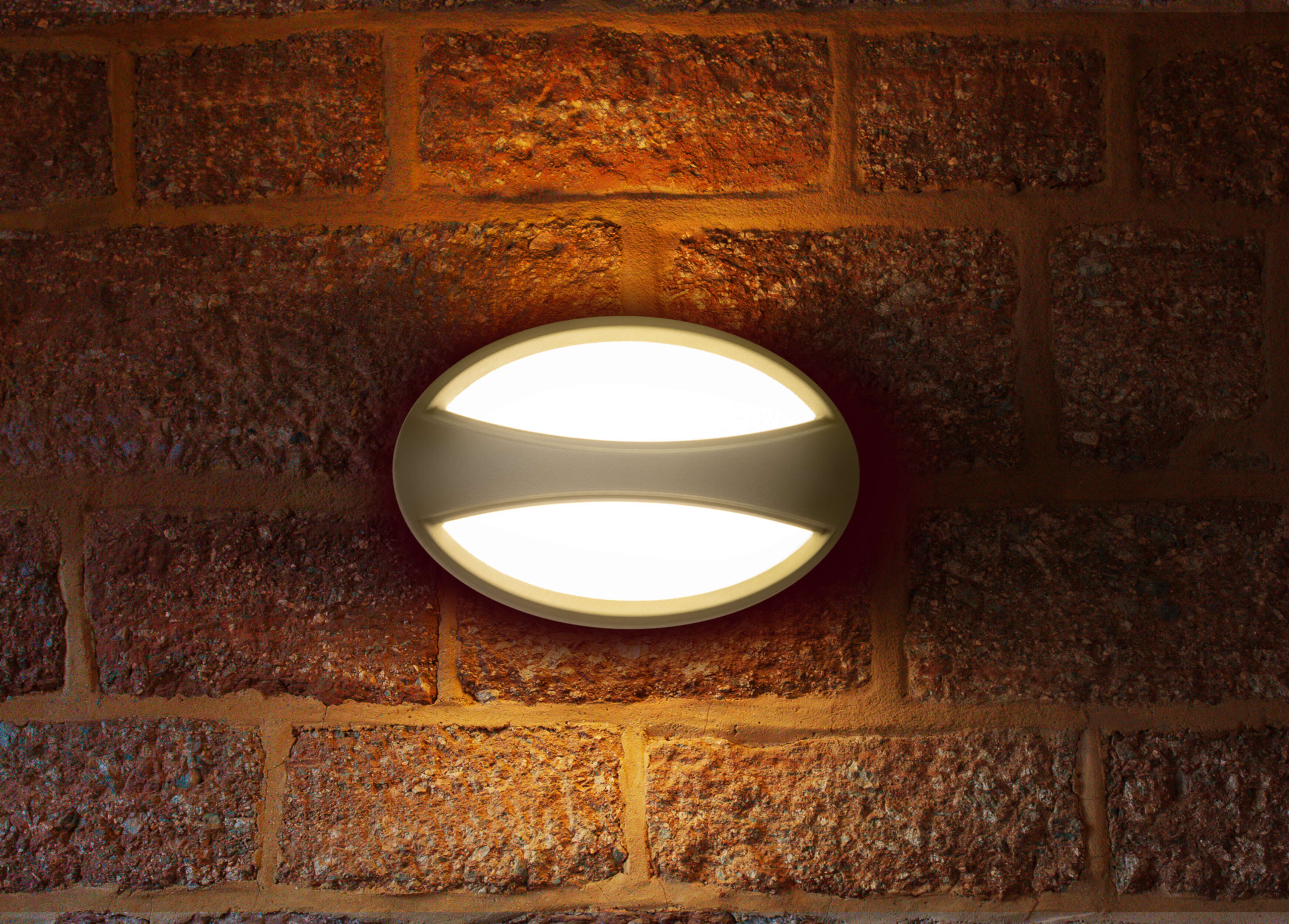 Ovale Wandleuchte an einer roten Backsteinmauer, die helles Licht ausstrahlt.