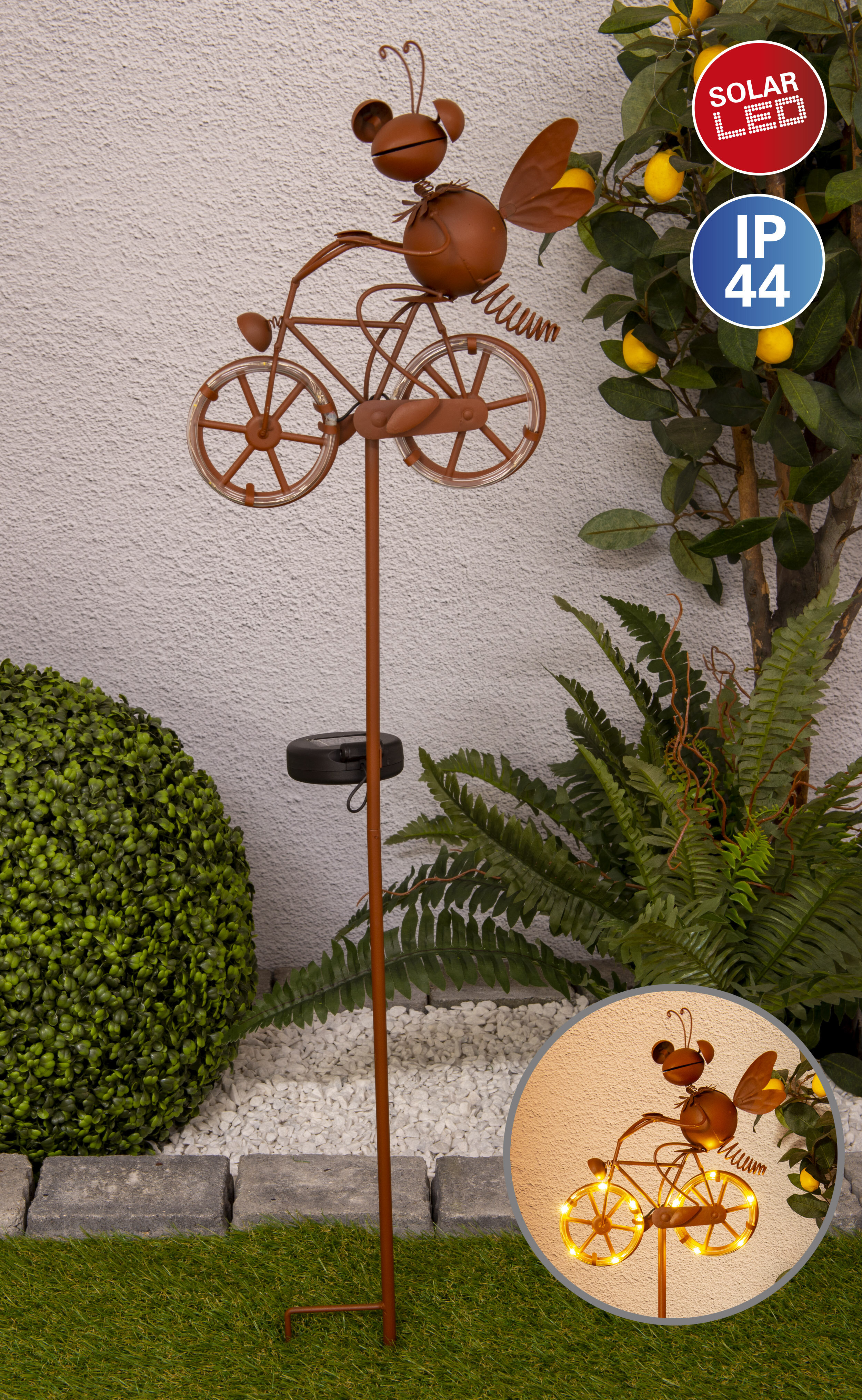 Solar LED-Gartenornament einer Biene, die Fahrrad fährt, mit einem Zitronenbaum im Hintergrund.