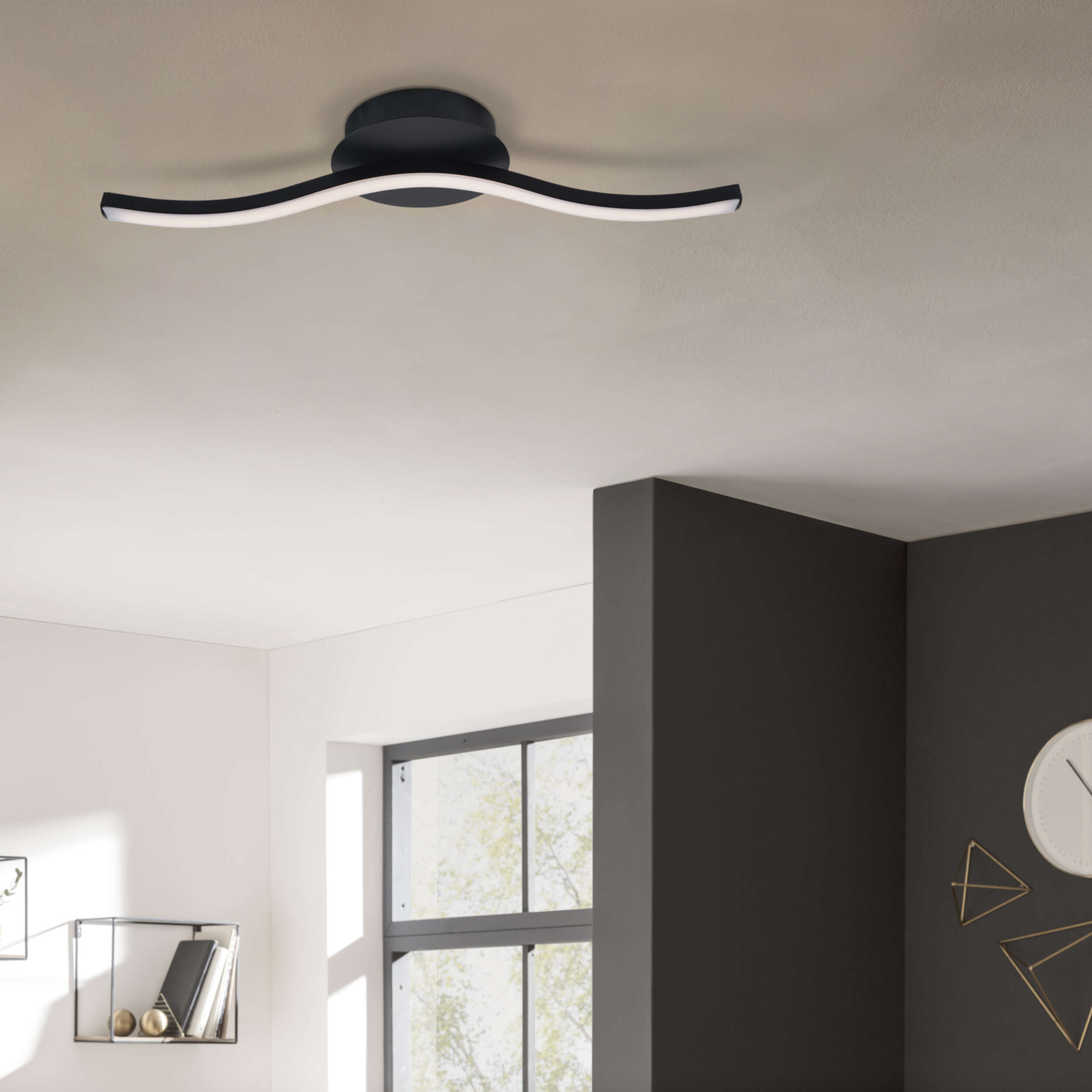 Deckenlampe. Zwei gebogene weiße Lichter auf schwarzem Sockel. Dunkelgrauer und weißer Hintergrund.
