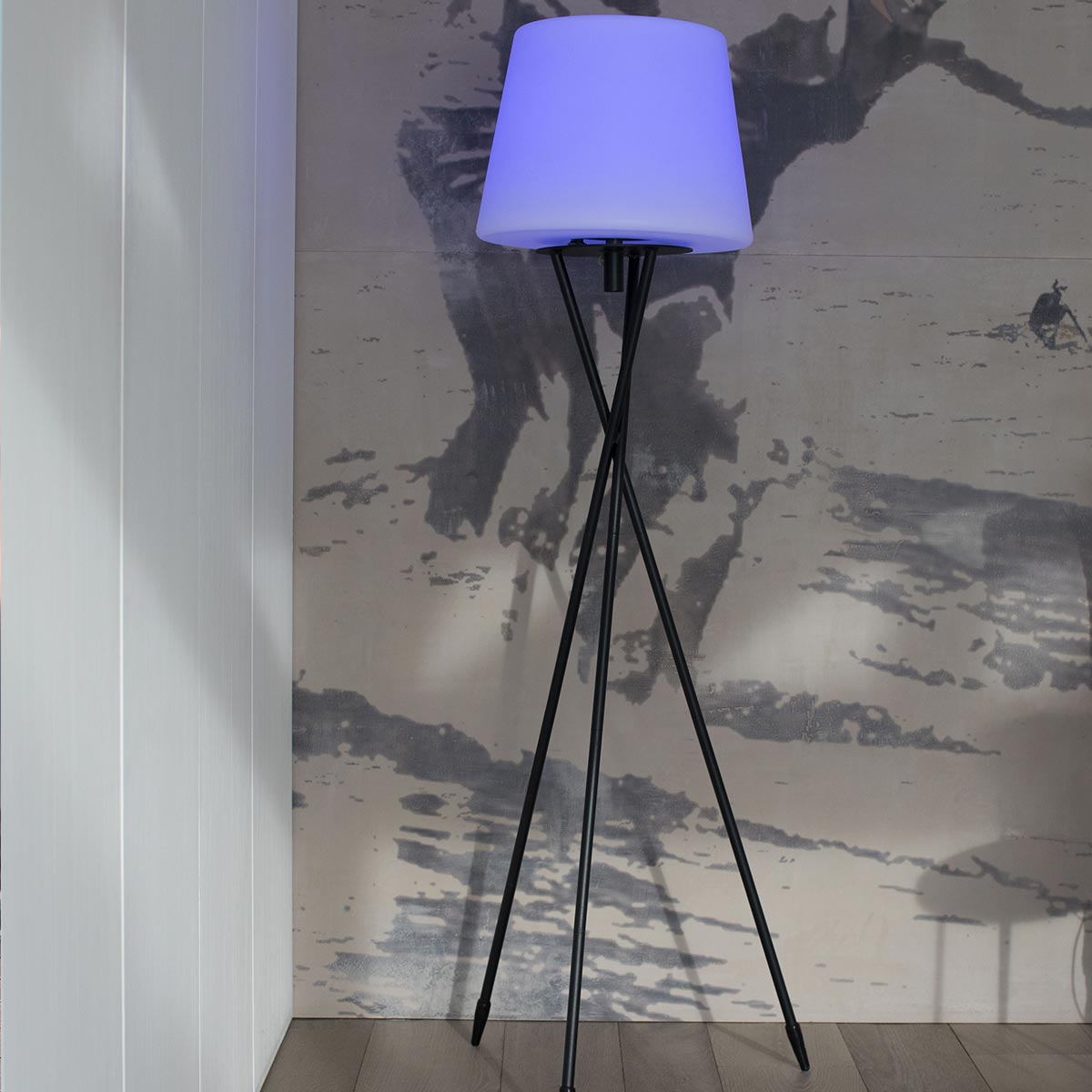 Schwarze Stativ-Stehlampe mit blauem Schirm, platziert in einer Zimmerecke.
