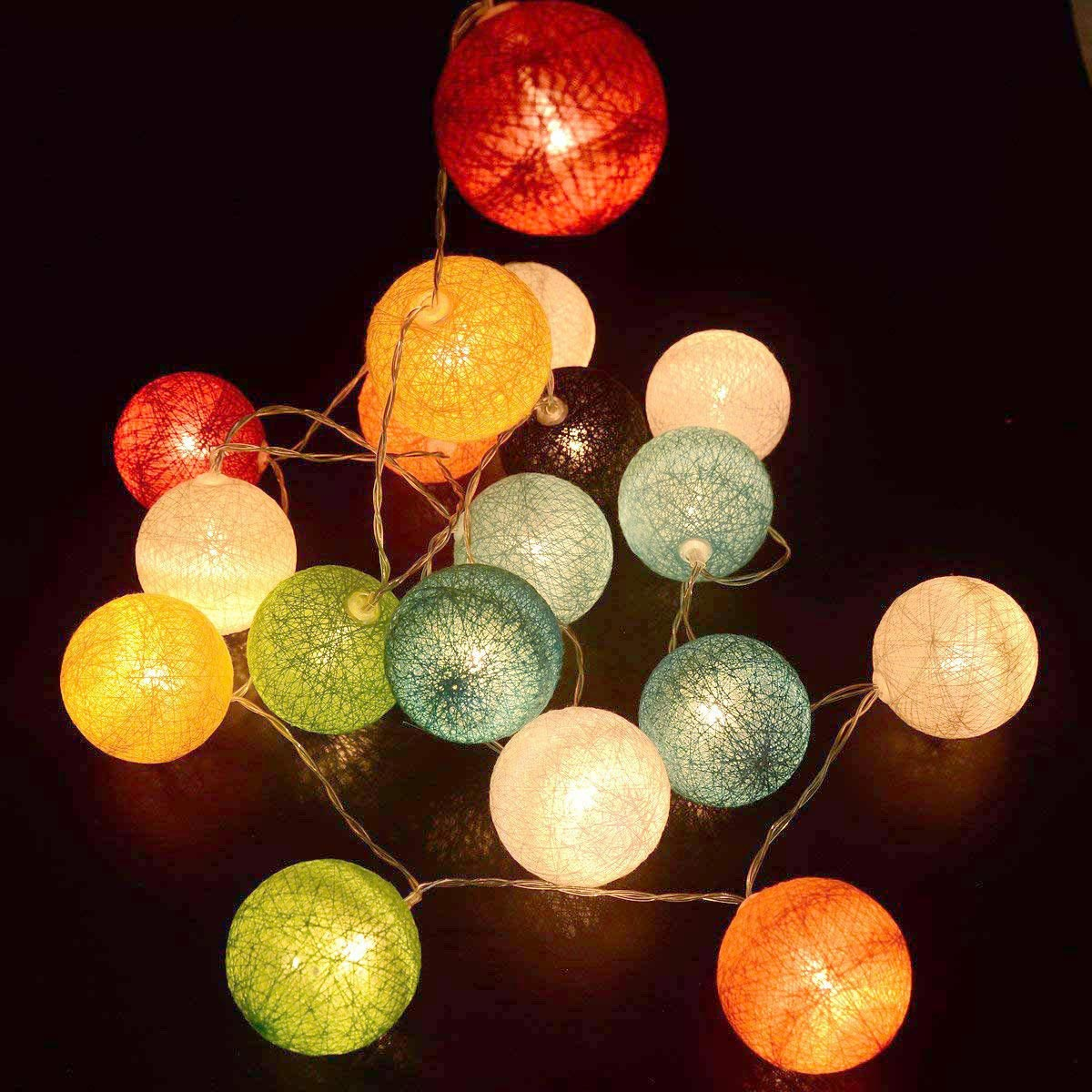 Lichterkette mit bunten Kugeln vor dunklem Hintergrund.