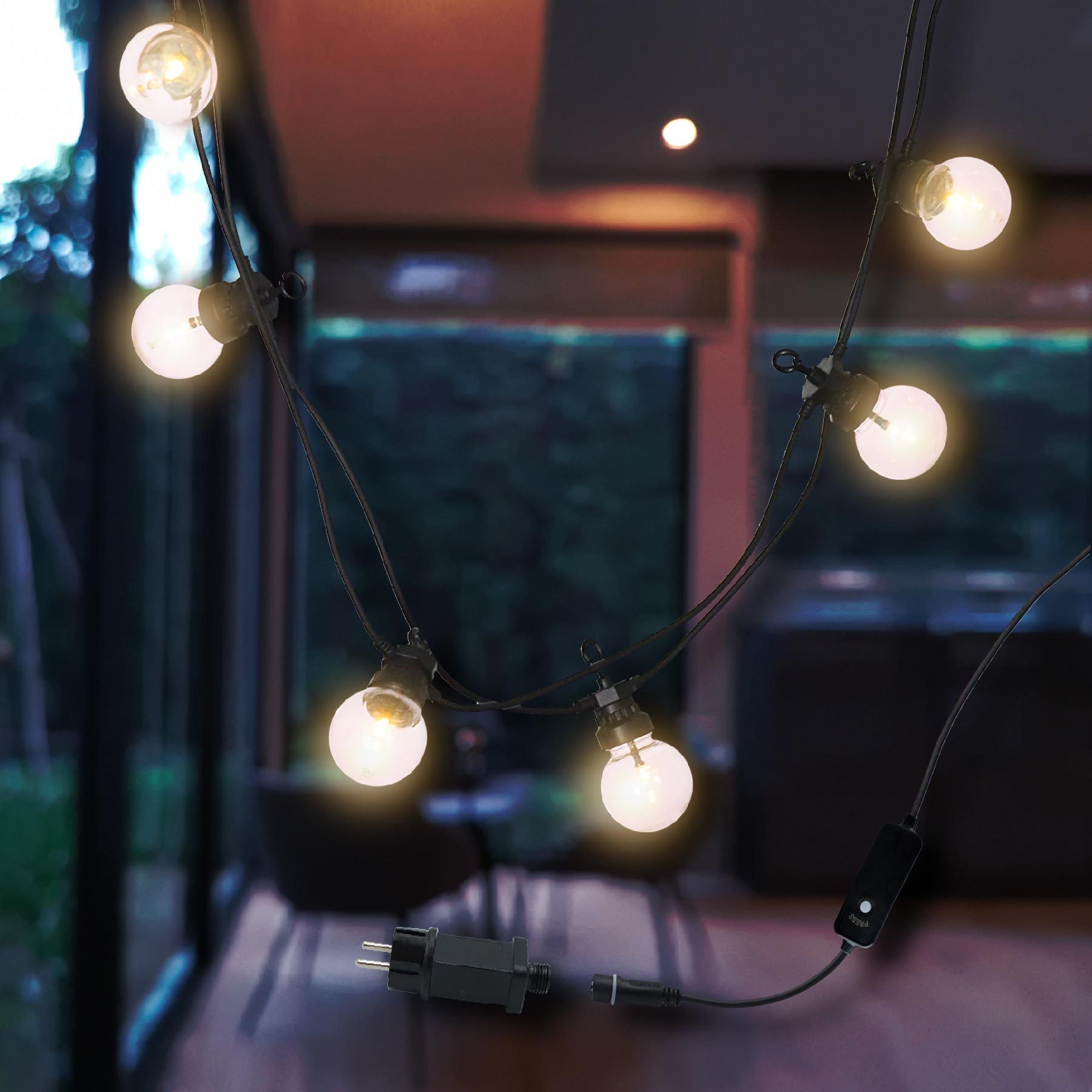 Lichterkette mit weißen Glühbirnen, drinnen mit dunklem Hintergrund.