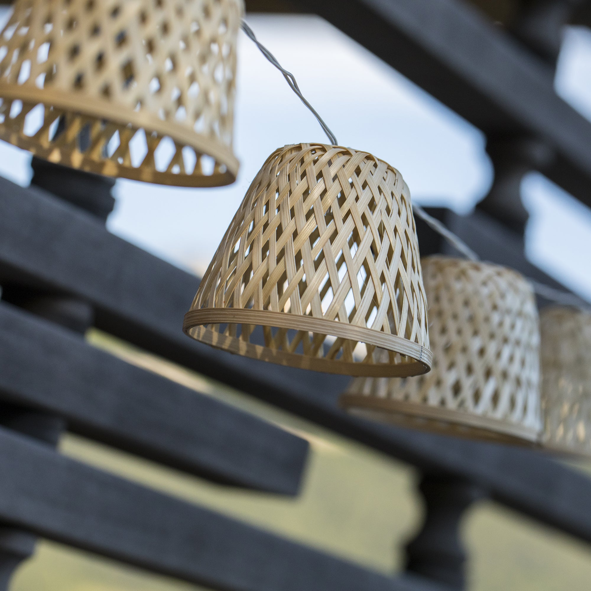 Hängende gewebte Lampen mit braunem Rahmen im Hintergrund.