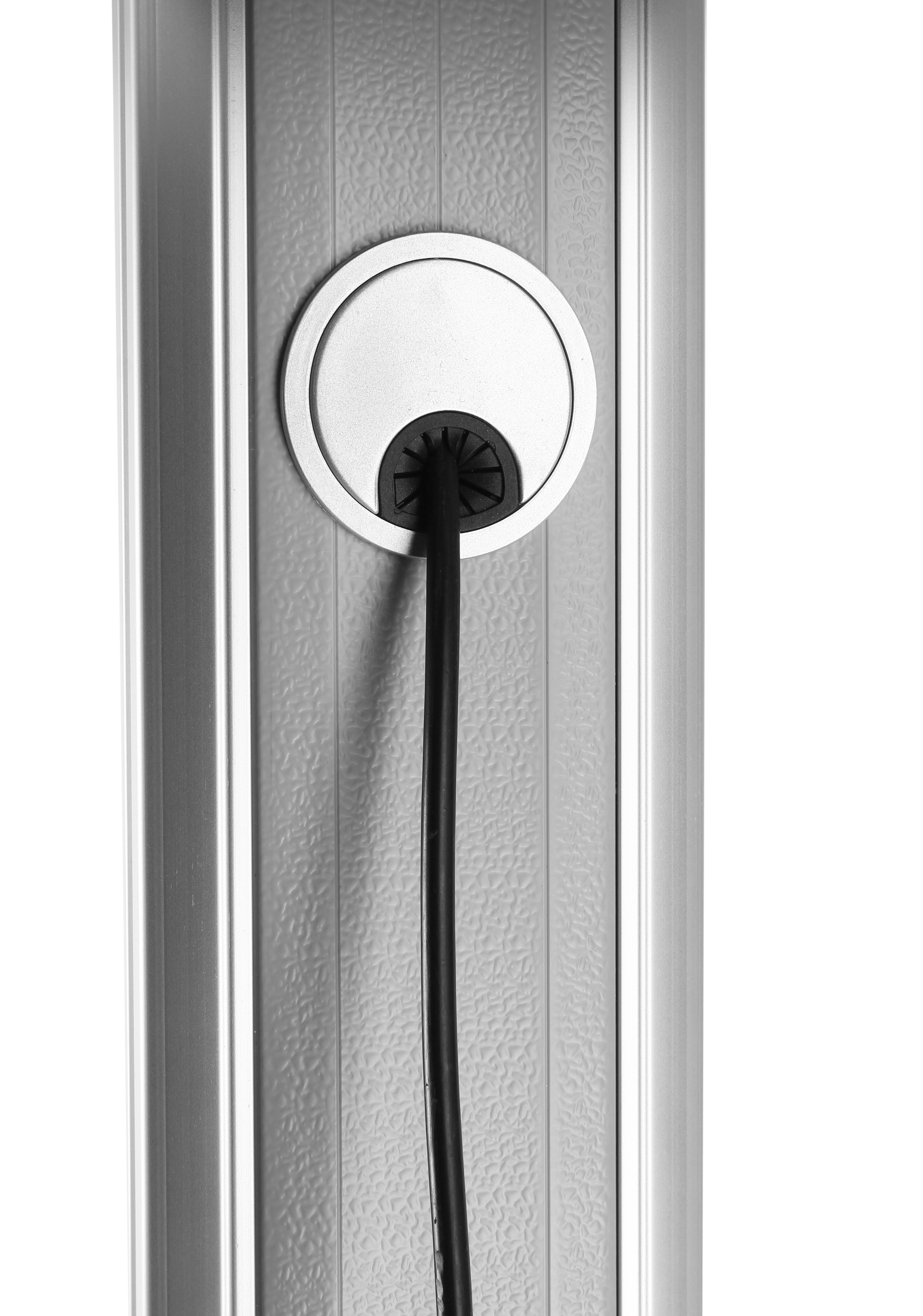 Primer plano de un enchufe de pared plateado con un cable de alimentación negro saliendo.