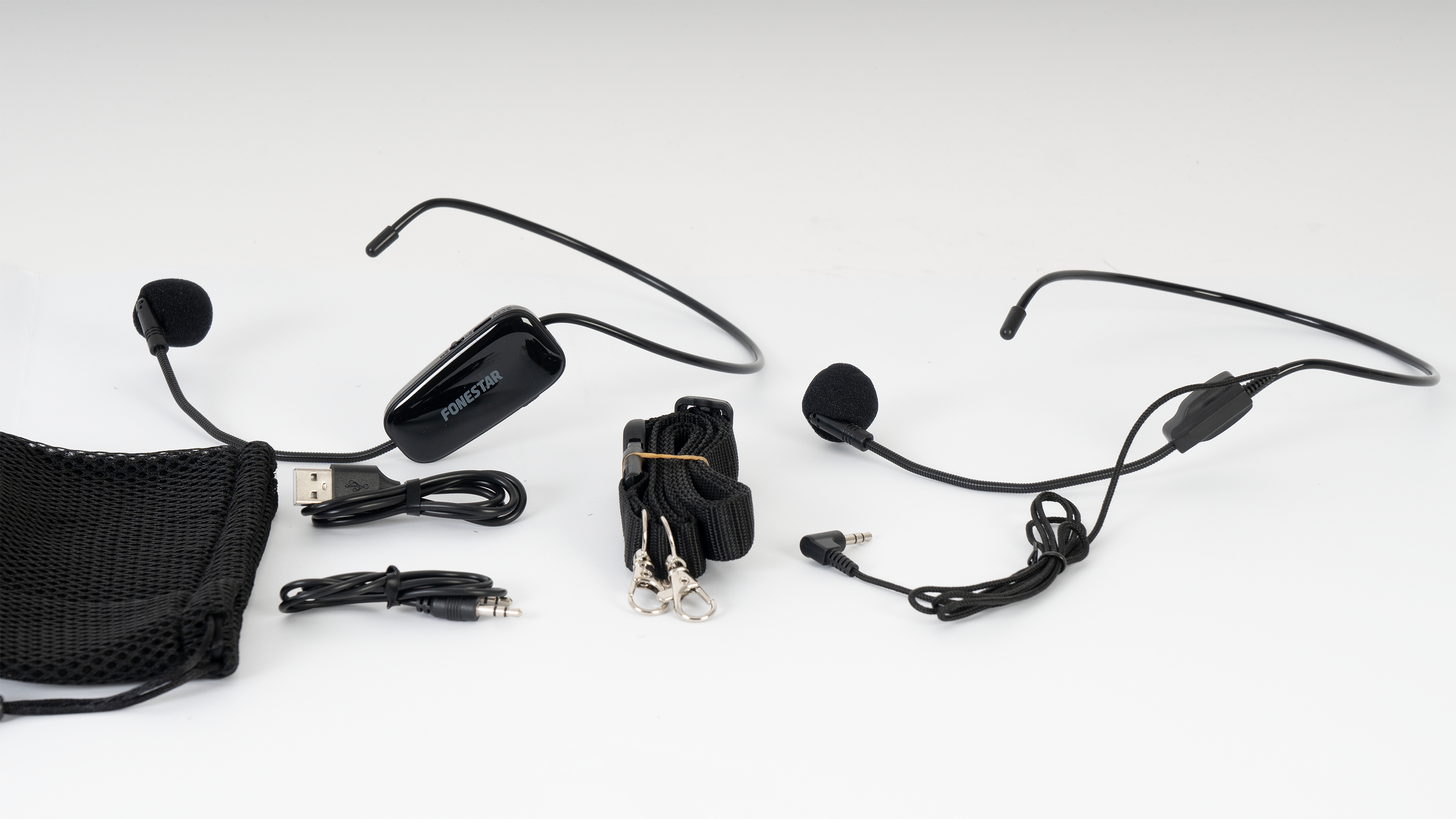 Un auricular inalámbrico en blanco y negro, con micrófono, cable USB y bolsa de transporte.