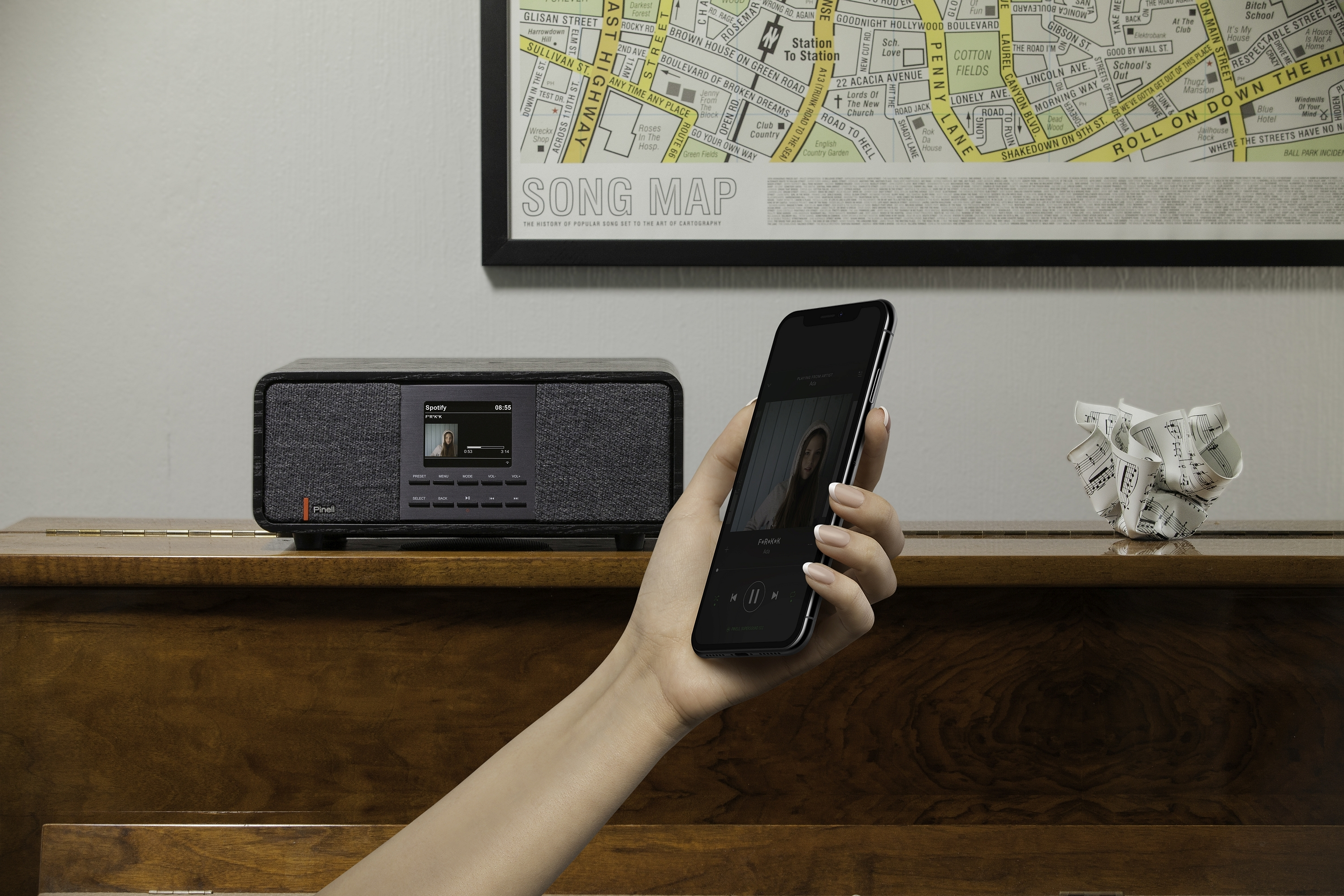Person holding a phone, playing music from Spotify, and a speaker.