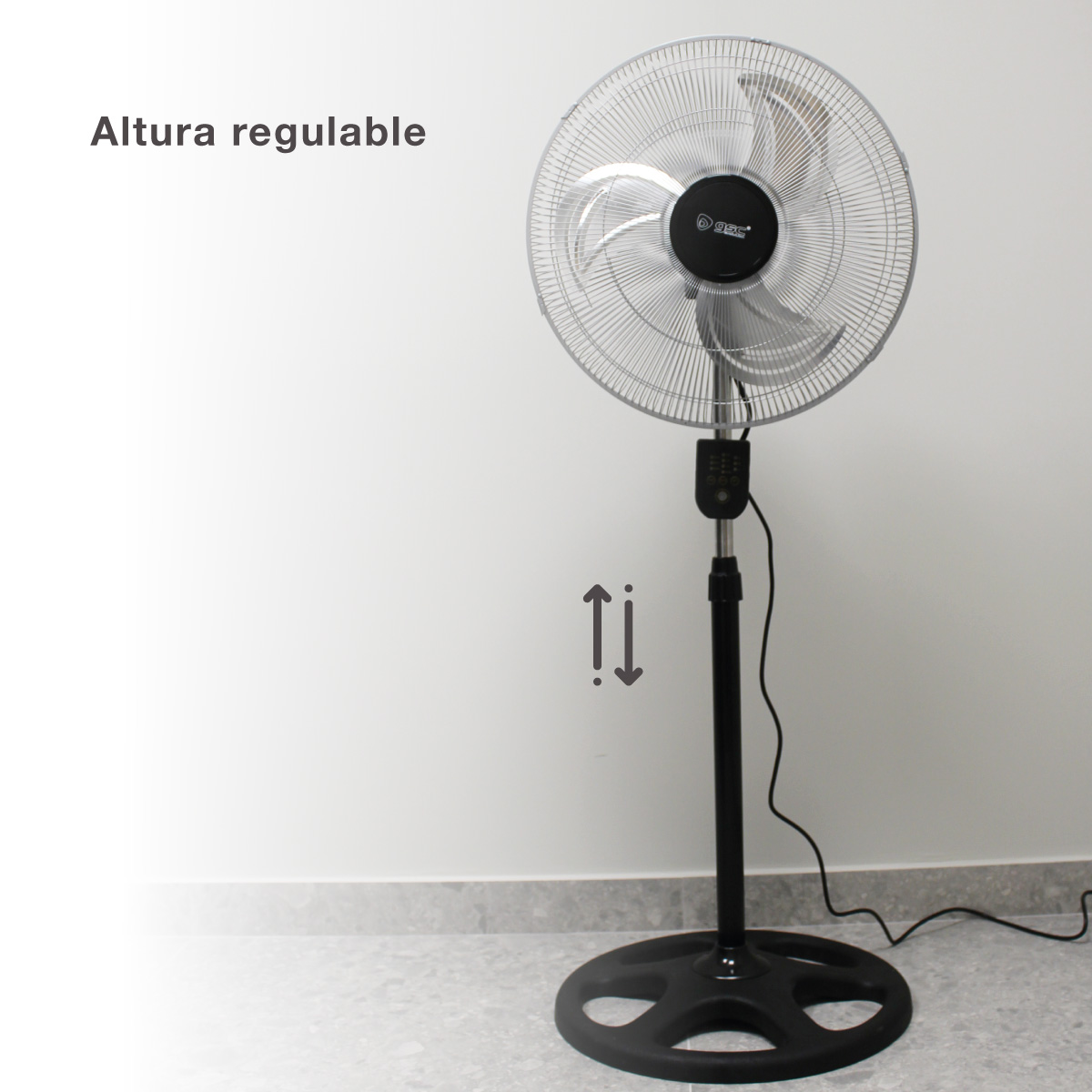 Un ventilador de pie plateado. Flechas indican altura ajustable. Fondo blanco.